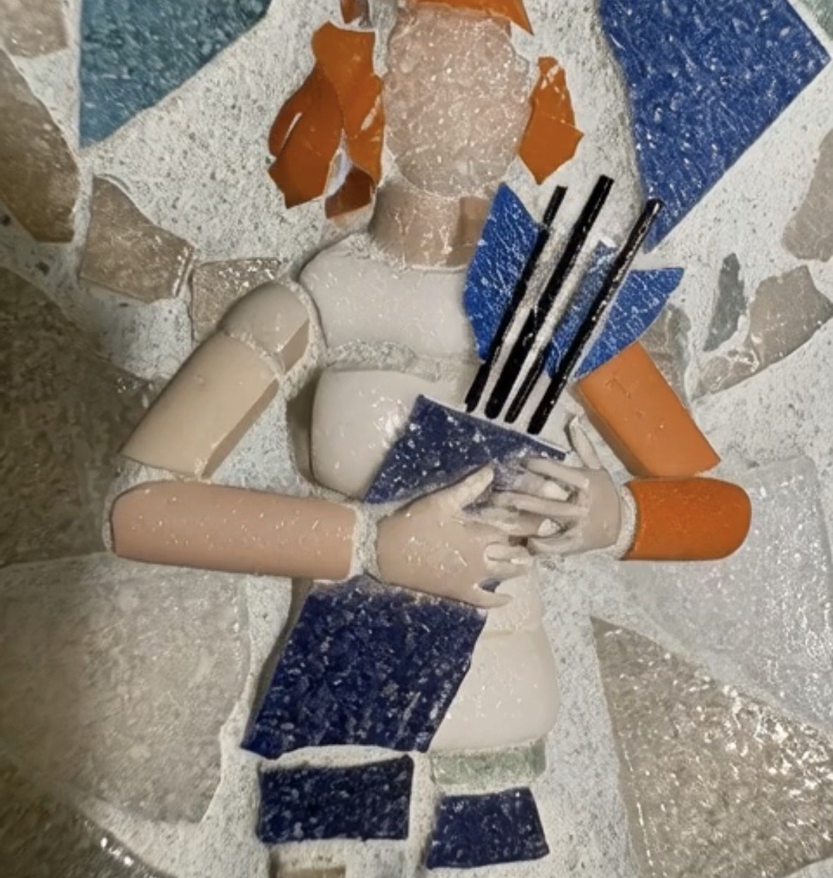 Mosaic art of a woman with orange hair, blue dress, holding shopping bags, and wearing orange sleeves.