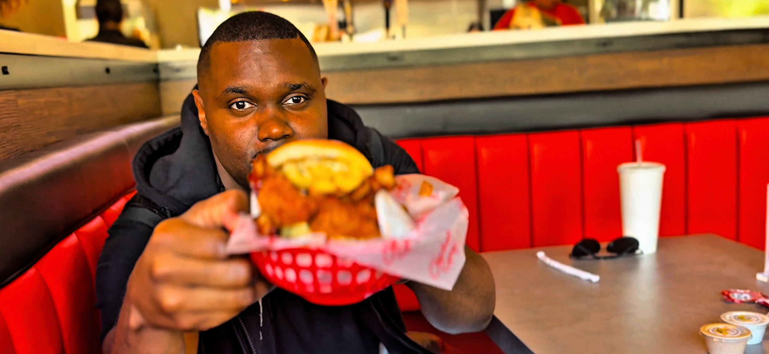 “Melvin Da Chef, a Dallas-based food reviewer, tasting a restaurant burger”