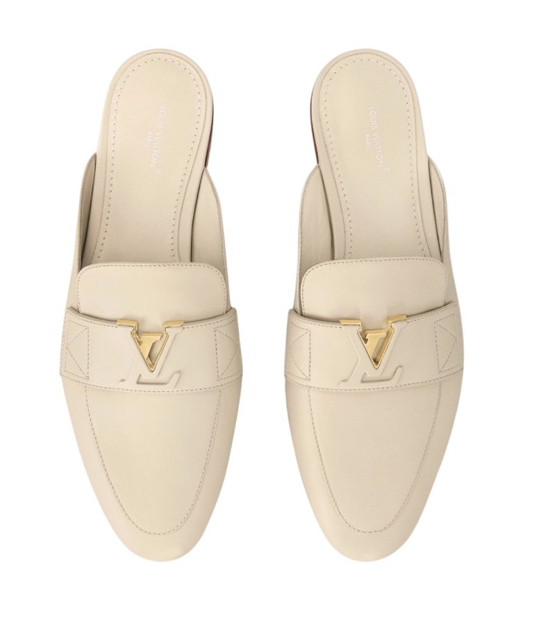 Pair of white Louis Vuitton loafers with gold LV logo embellishment. Perfect to wear from work - evening.