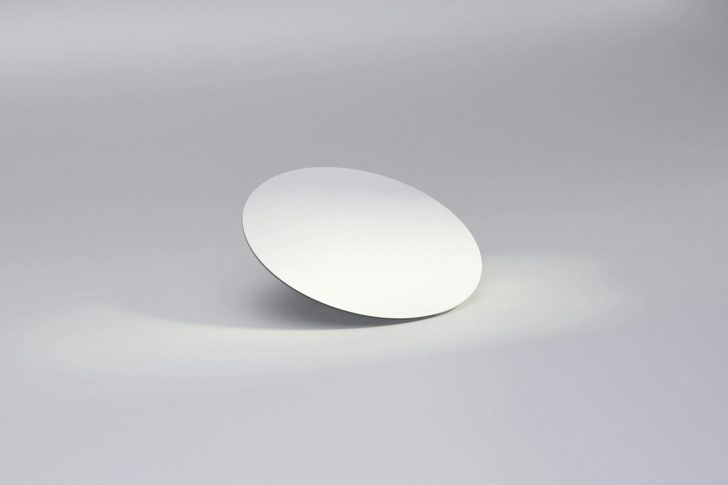 A white egg placed on a reflective gray surface with a gray background.