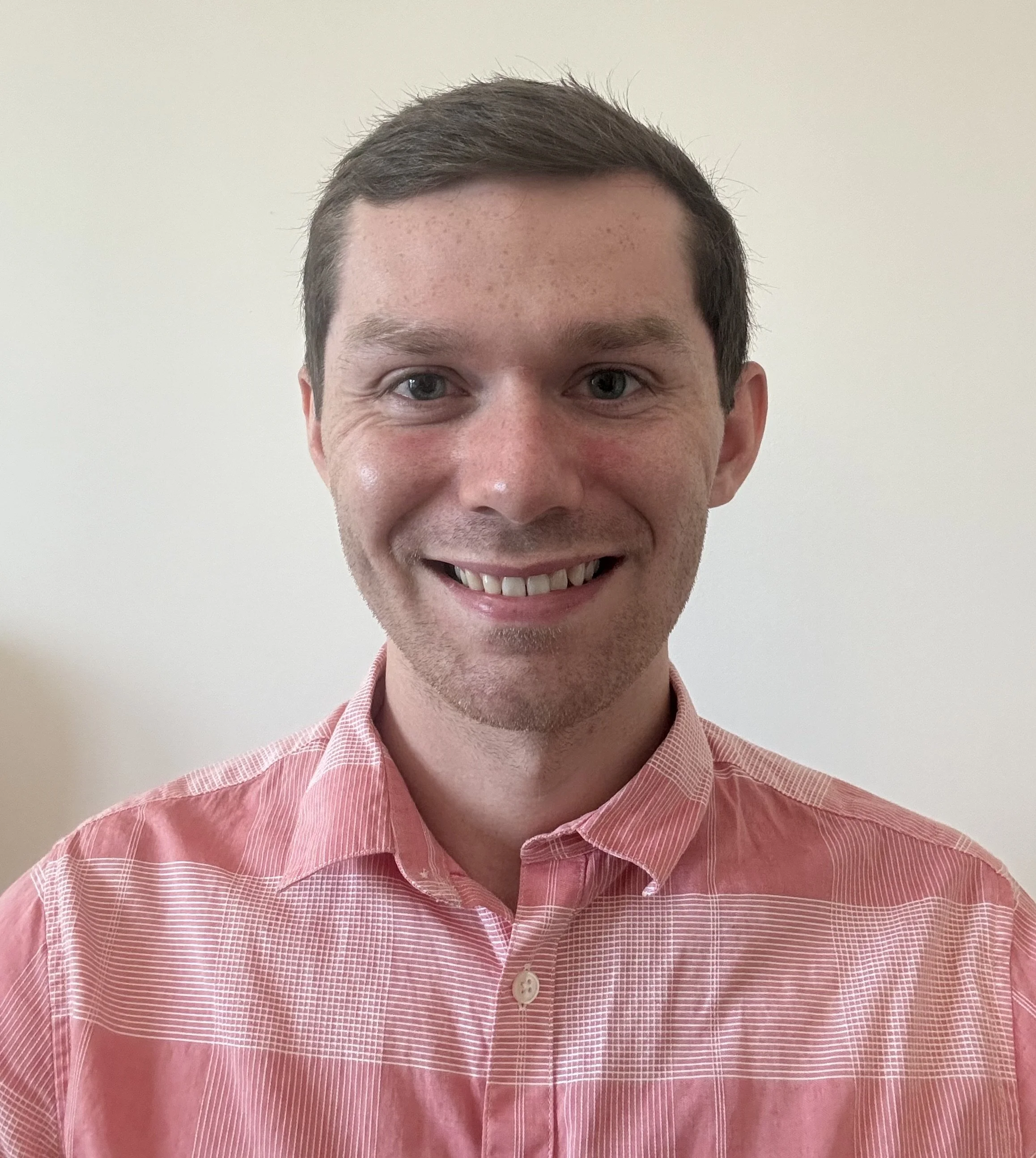 A licensed marriage and family therapist smiling and looking at the camera with a blank background.