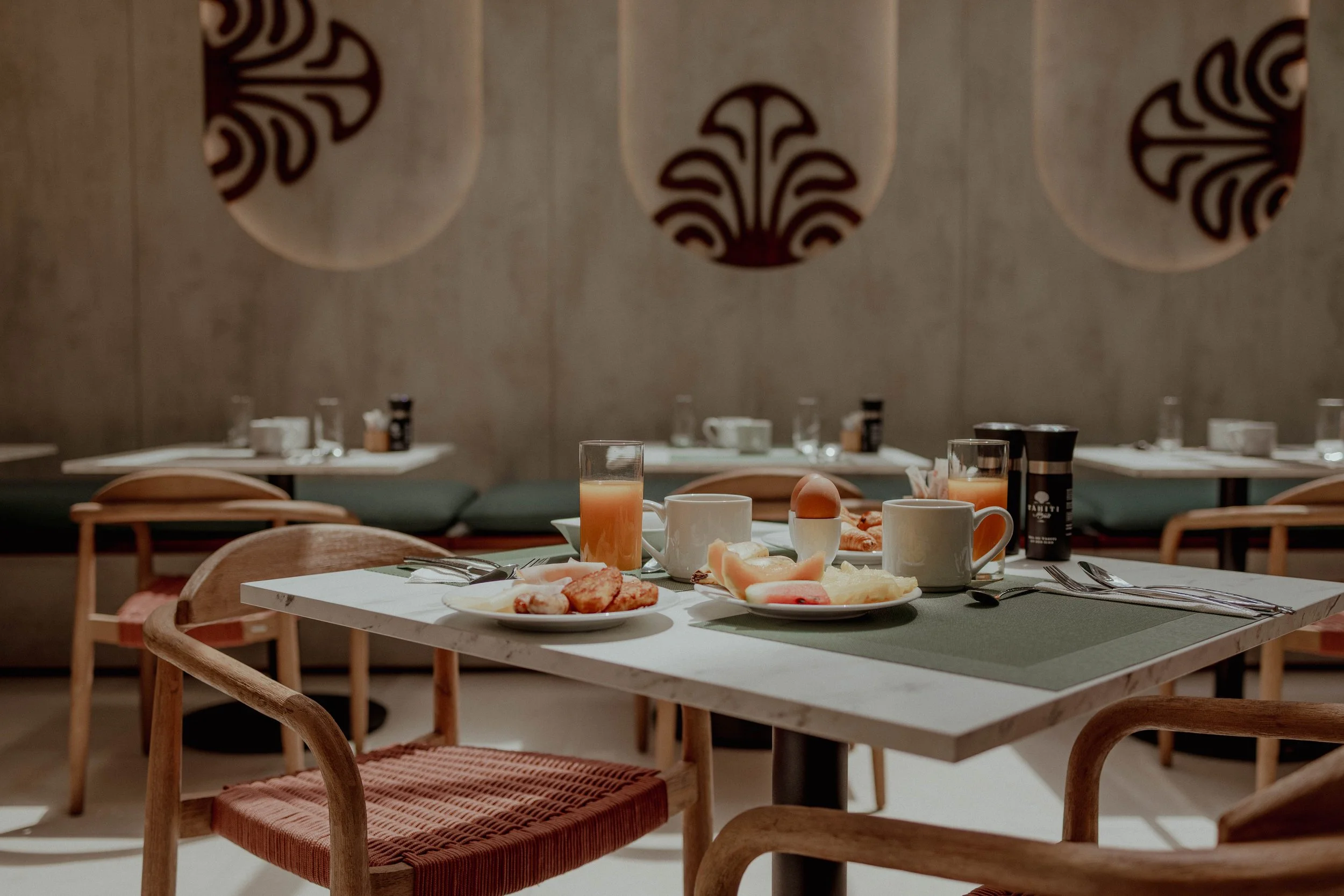 Table de petit-déjeuner avec œufs, fruits, pain, boissons et mug dans un restaurant moderne
