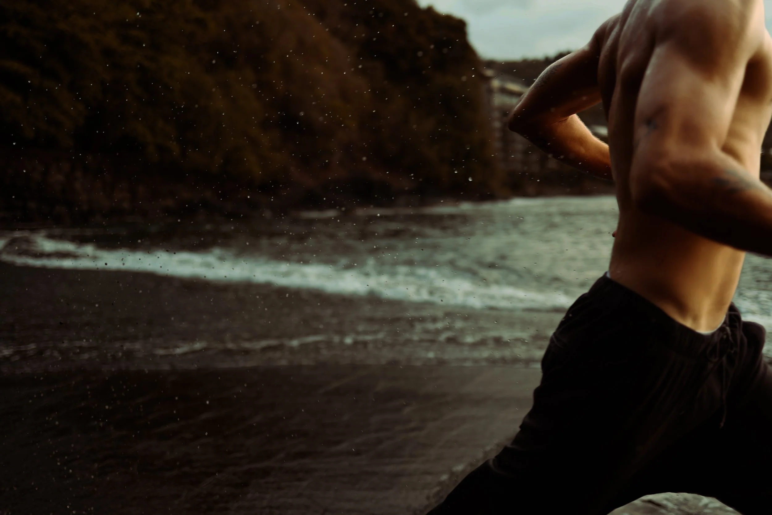 Personne courant sur la plage en maillot de bain, avec des vagues en arrière-plan.