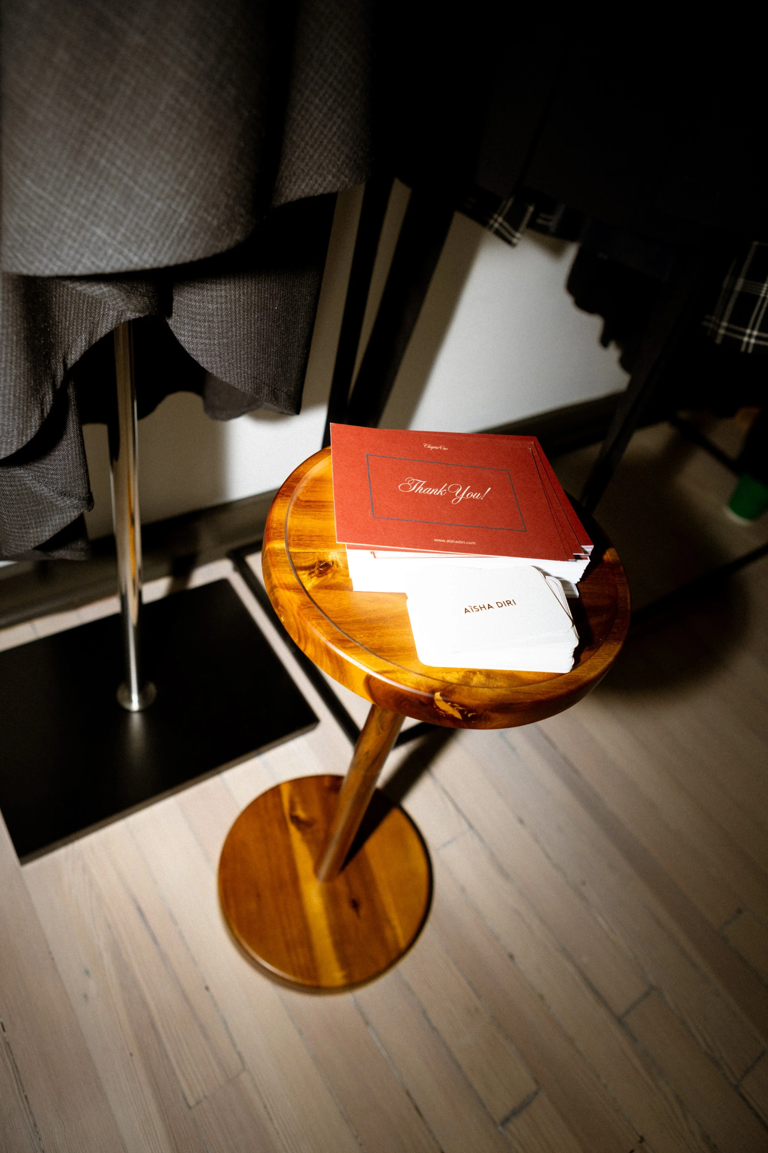 Thank you cards and name tags on a wooden stand in a boutique or event setting.