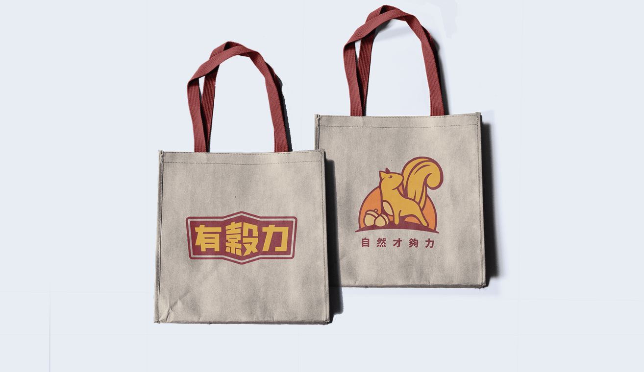 有穀力品牌帆布提袋實體展示，呈現標誌與松鼠圖形設計