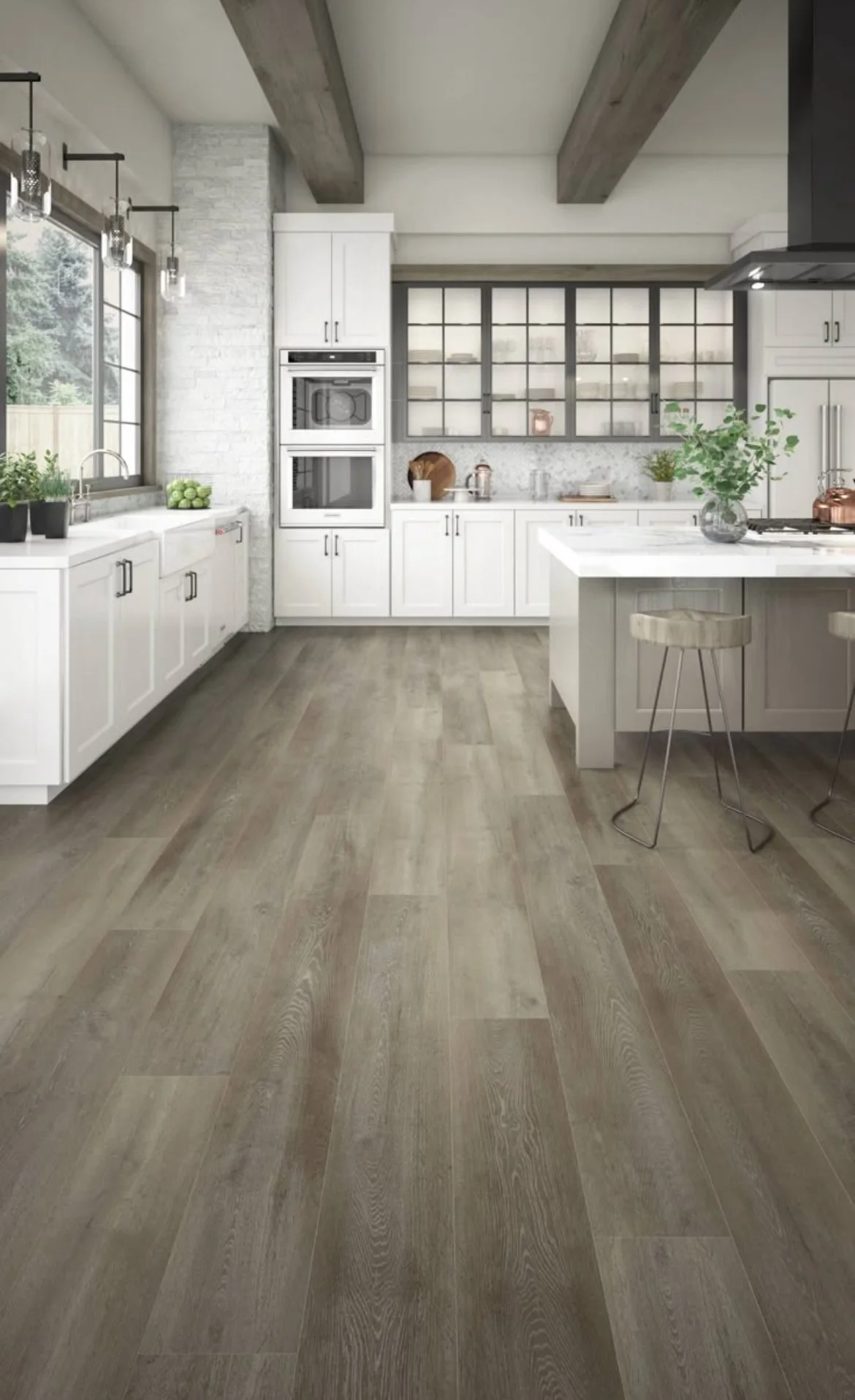 Modern kitchen with white cabinets, wood flooring, and large windows, decorated with plants and kitchenware.
