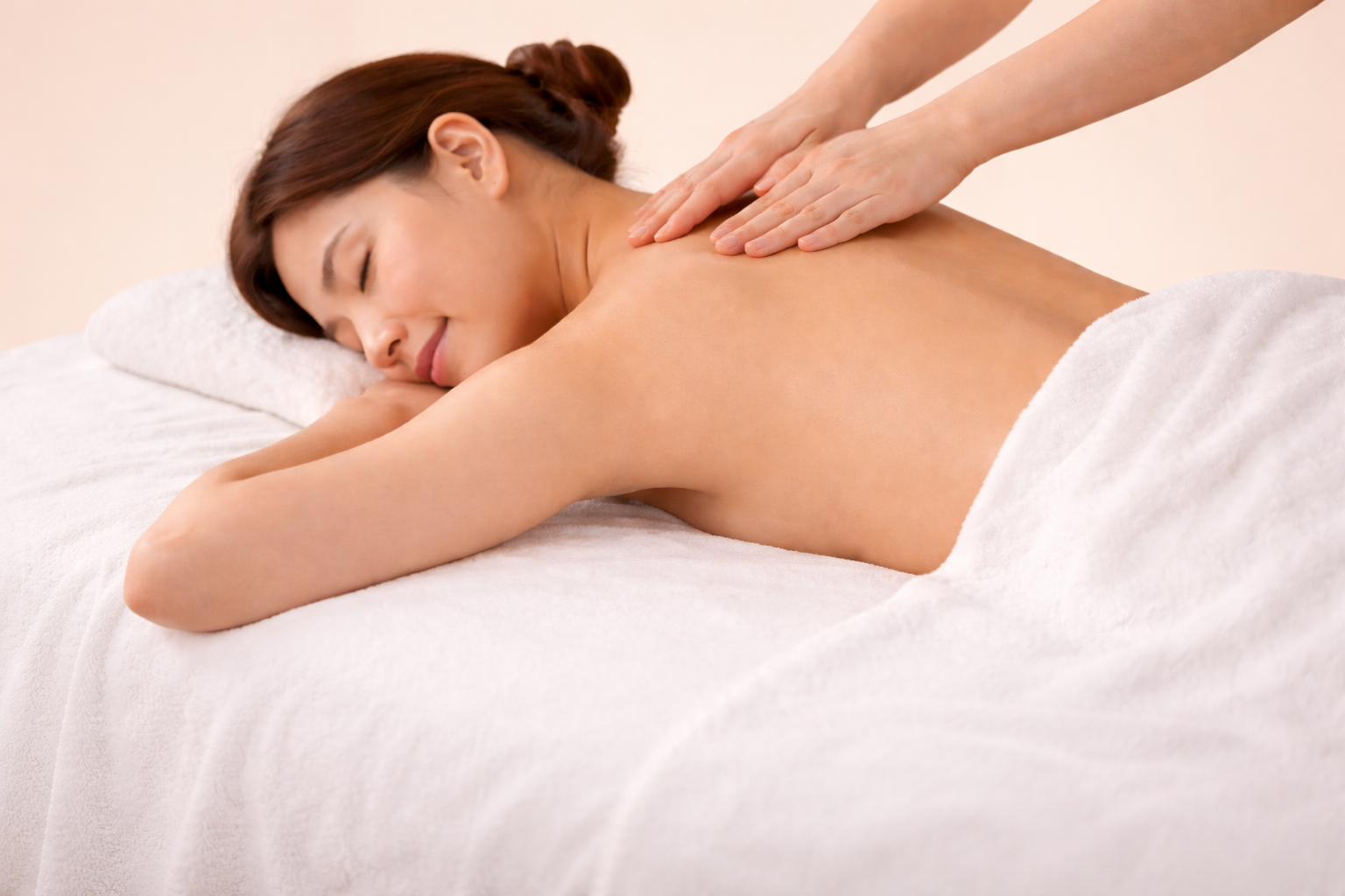 A woman receiving a professional therapeutic massage focused on back and muscle tension relief at Avy Spa.