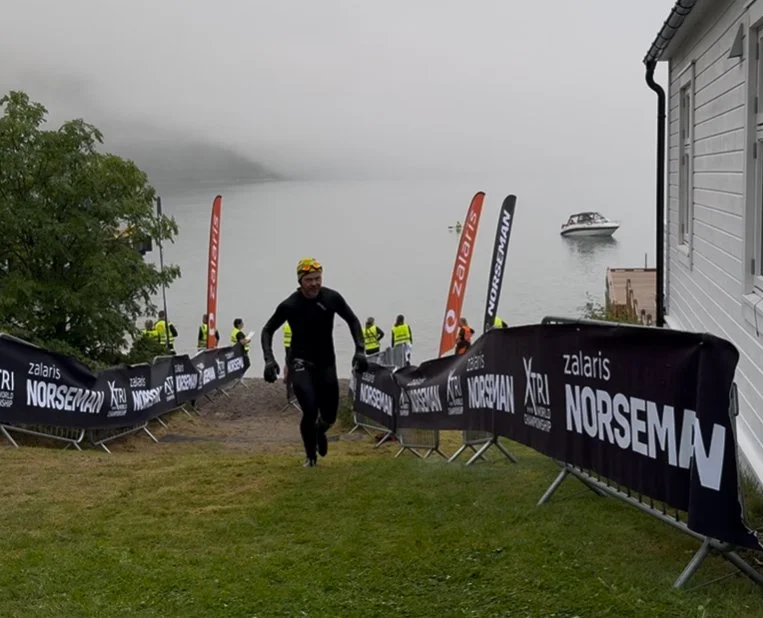 Coach Jørstad kommer her opp fra vannet etter å ha fullført første etappe i Norseman 2025.