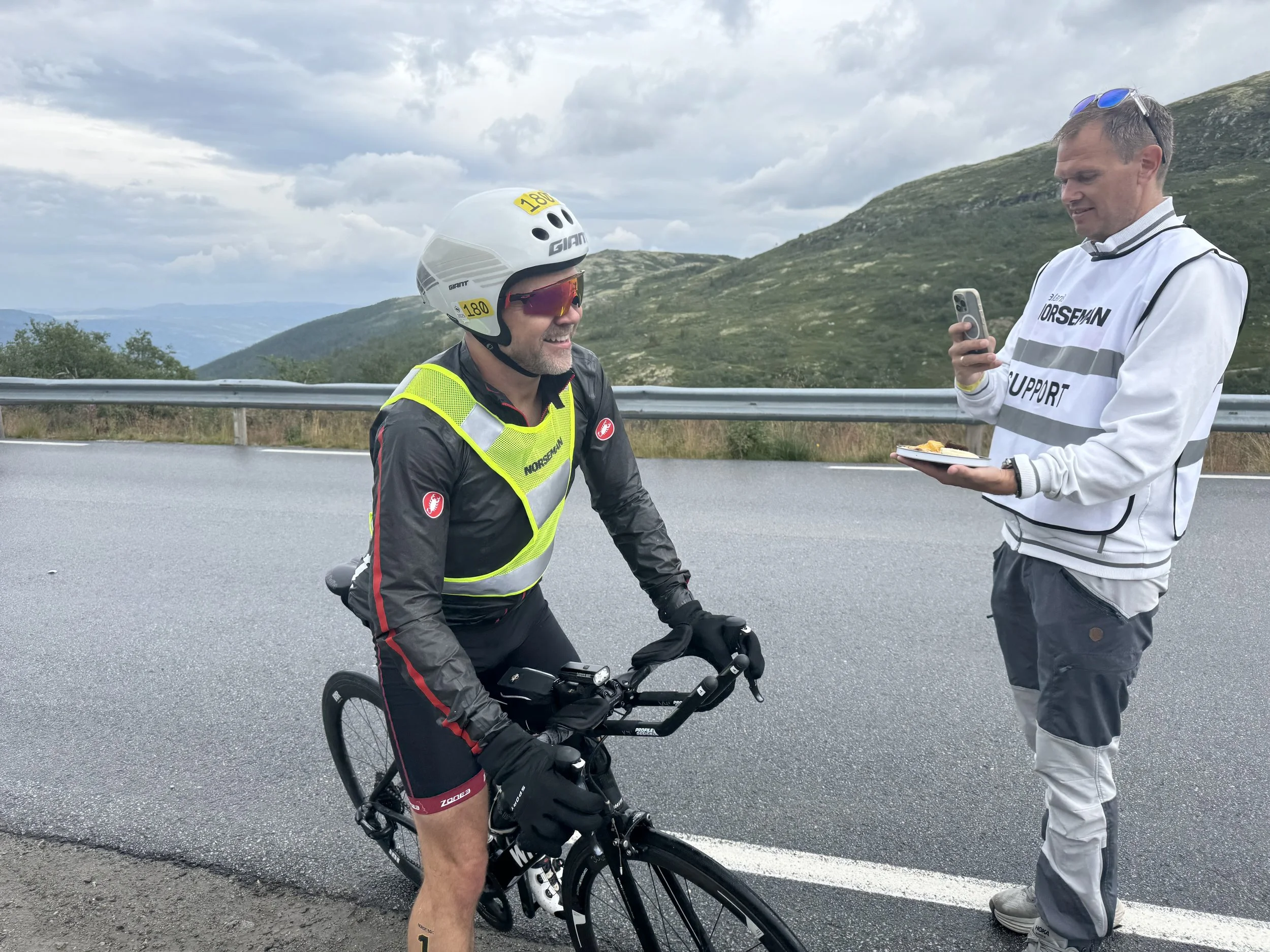 Coach Jørstad får her litt snacks av sin support under Norseman 2025.