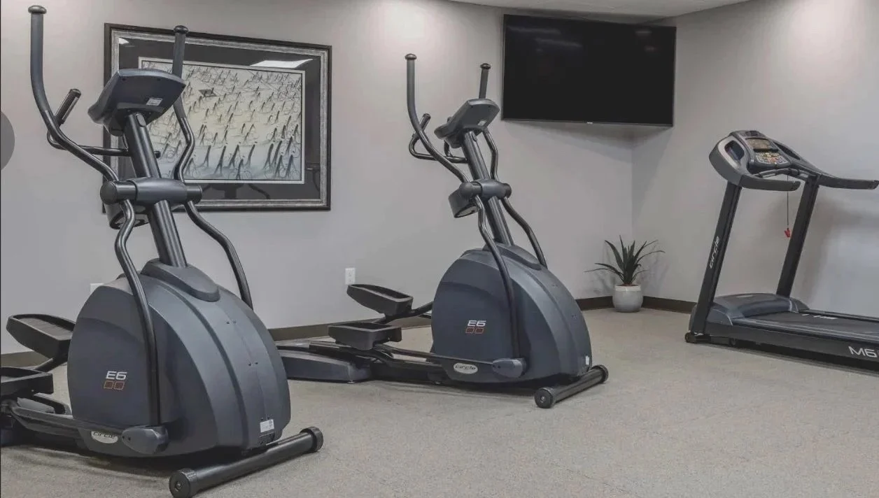 An on-site fitness room equipped for cardio and strength training, open daily for guest use.