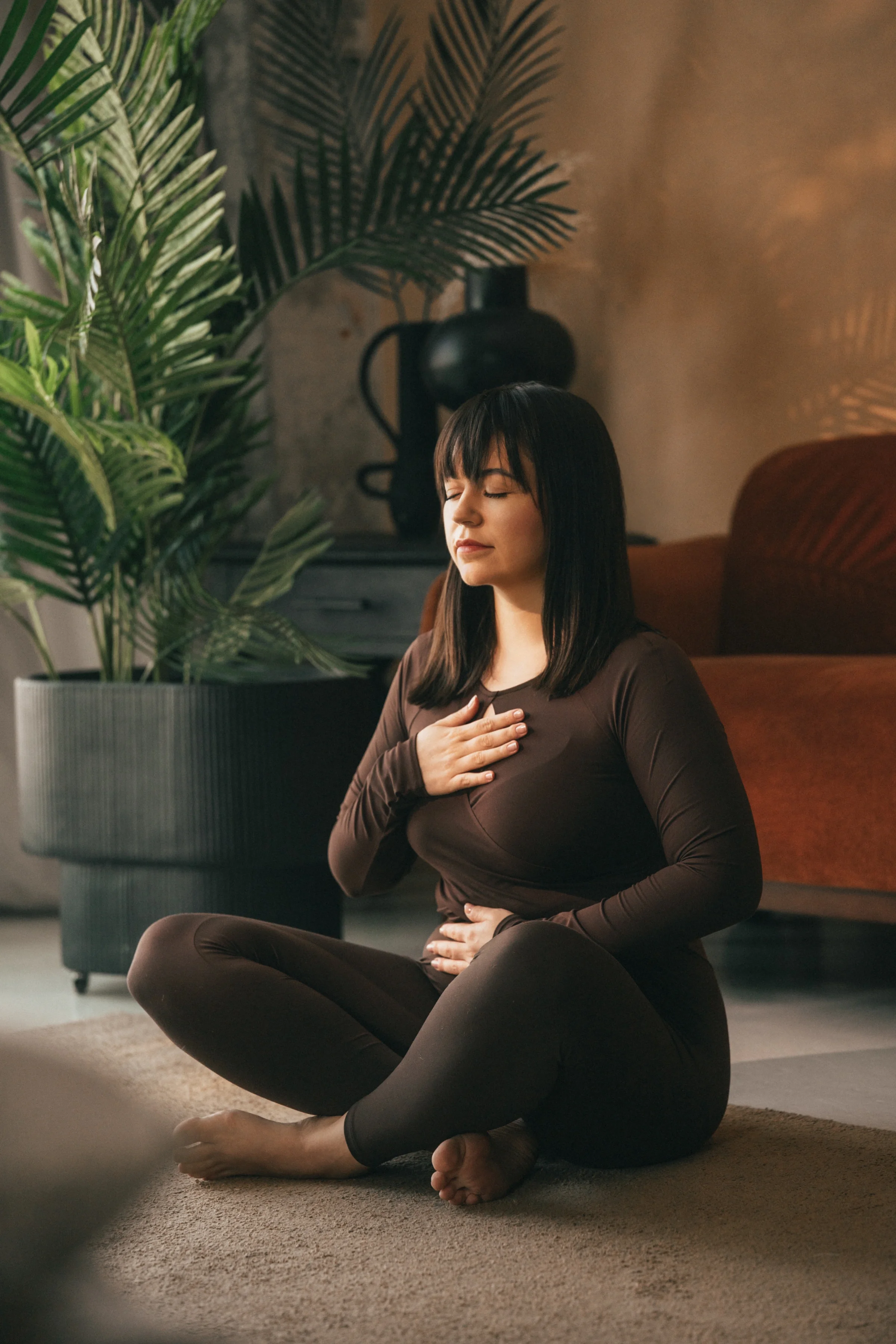 Vanessa Hartmann practicing a nervous system regulation breathing technique with one hand on chest and one on belly during a somatic breathwork session in Dubai.