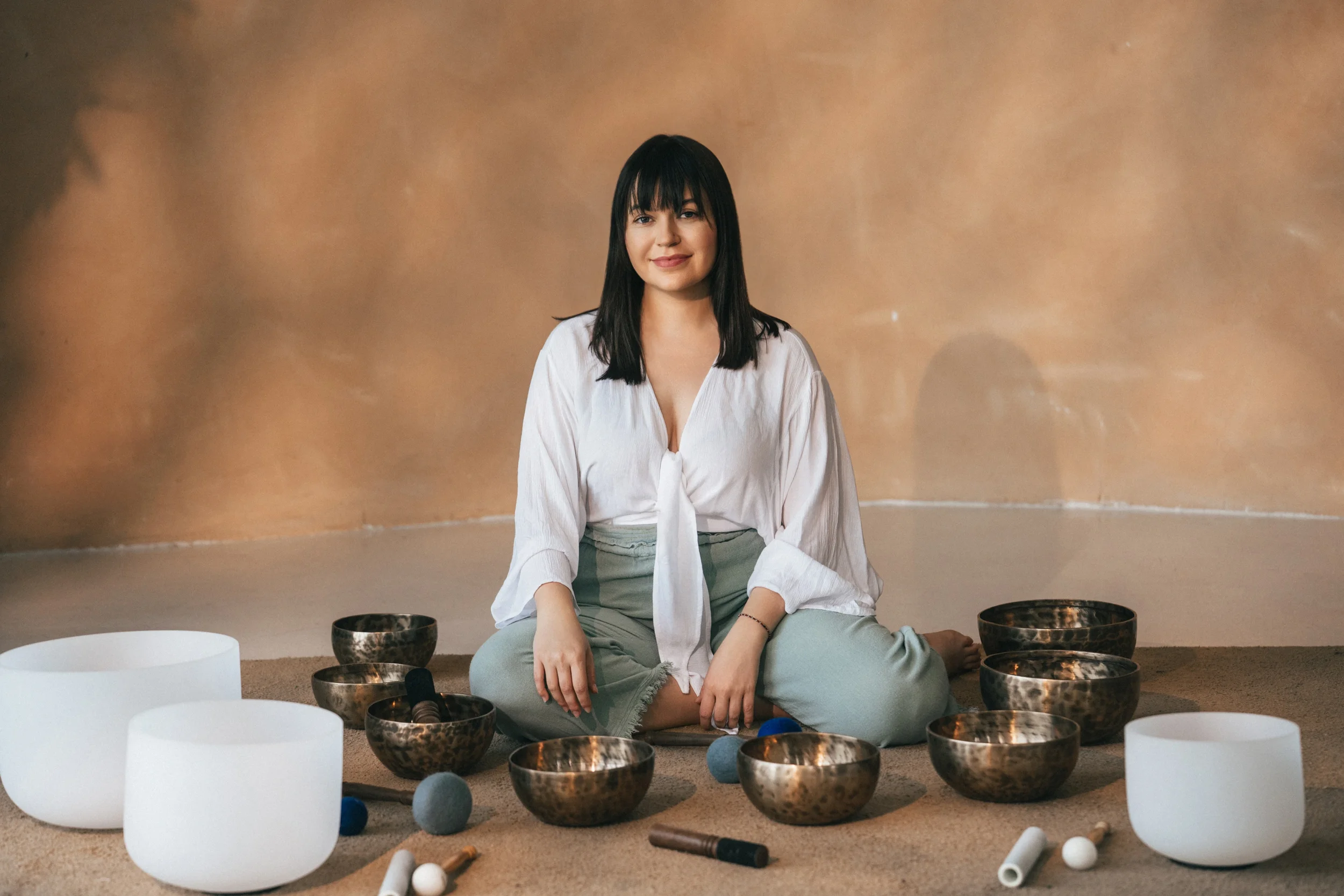 Sound healer Vanessa Hartmann seated with Tibetan singing bowls during a trauma-informed sound healing session supporting nervous system regulation, stress relief and deep relaxation in Dubai.