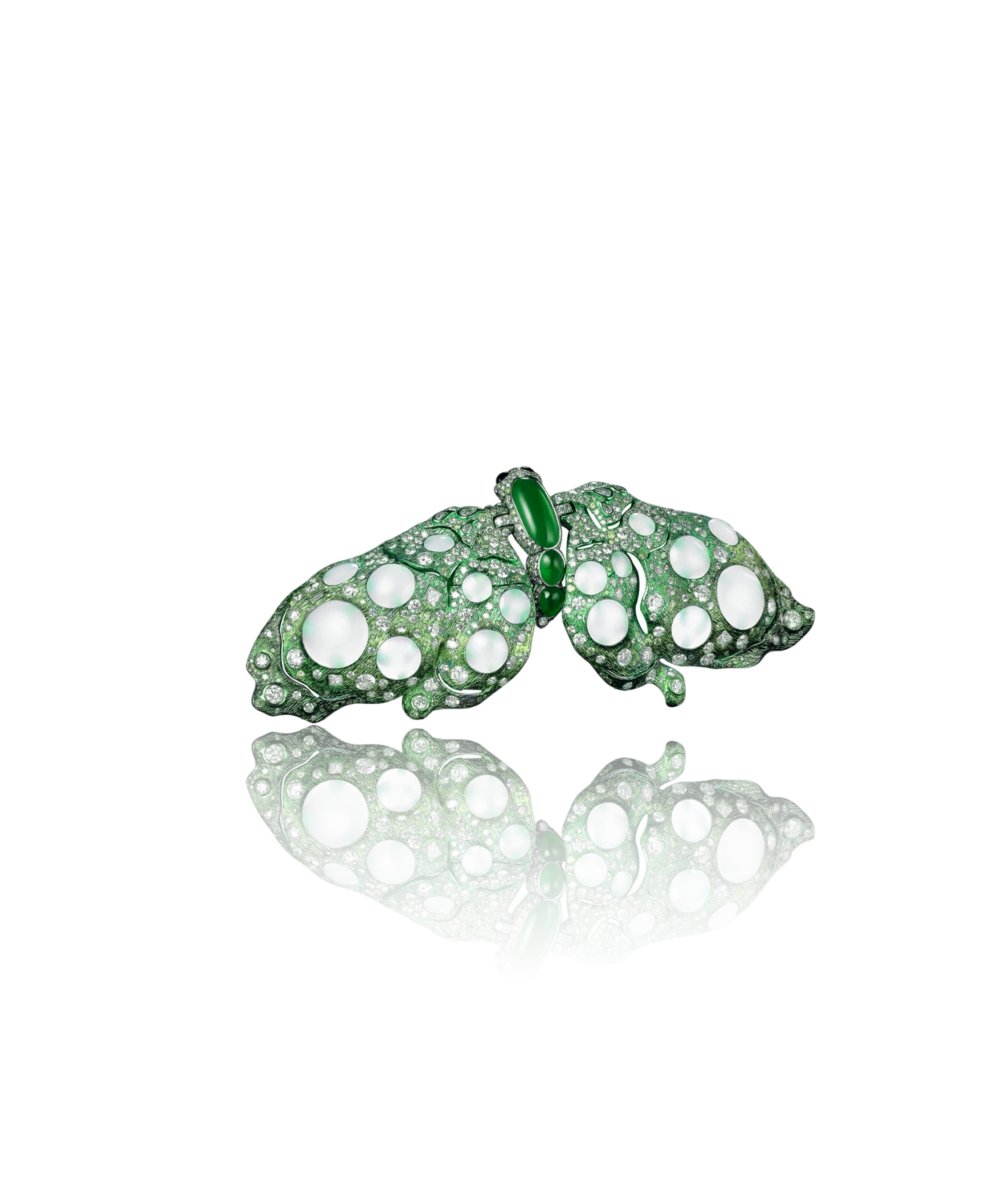 A jewelry piece shaped like a butterfly, decorated with green and white gemstones, with the butterfly's wings spread open and a mirror reflection beneath.