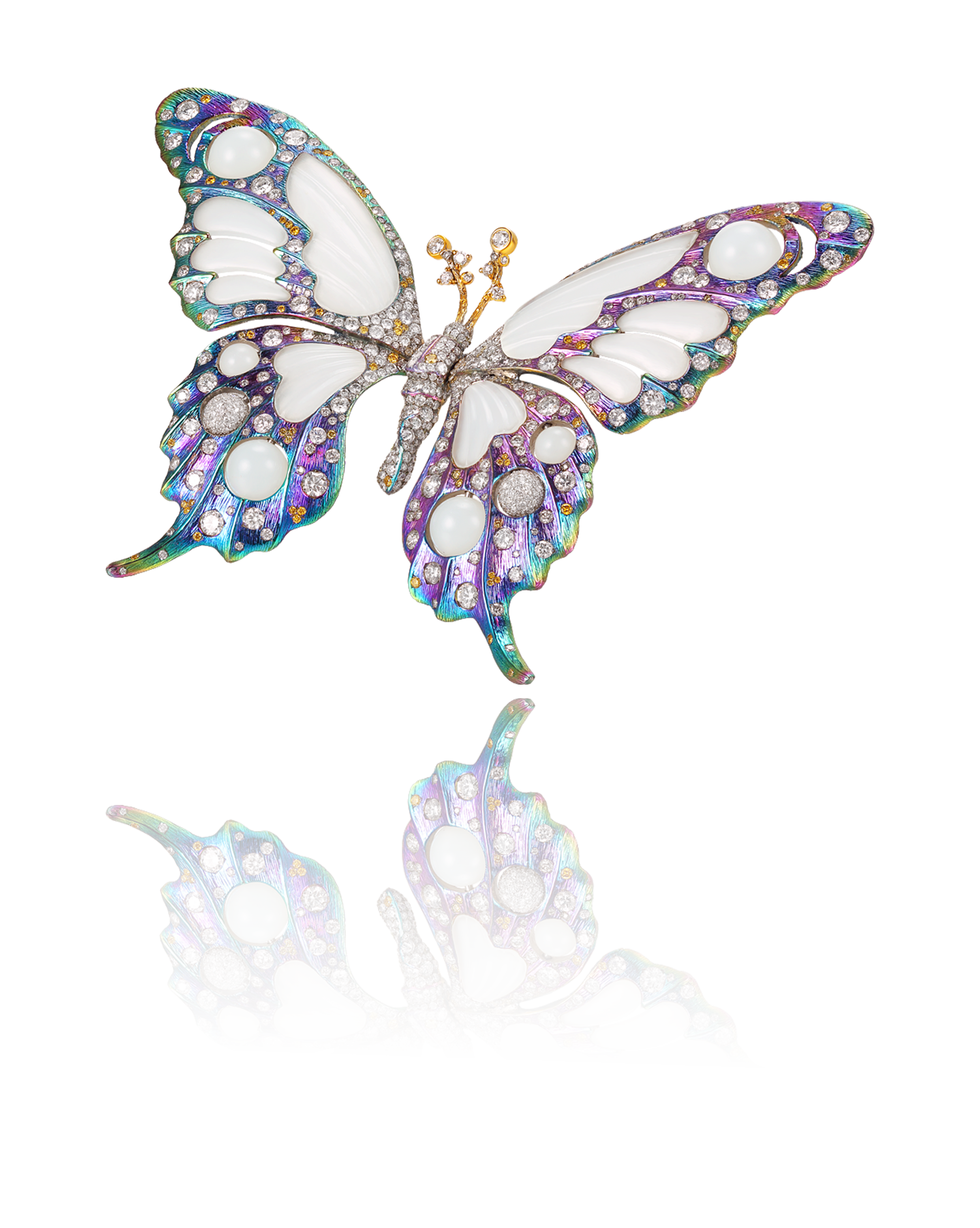 Decorative butterfly jewelry brooch with white enamel, pearls, and colorful gemstones, reflected on a black mirror surface.