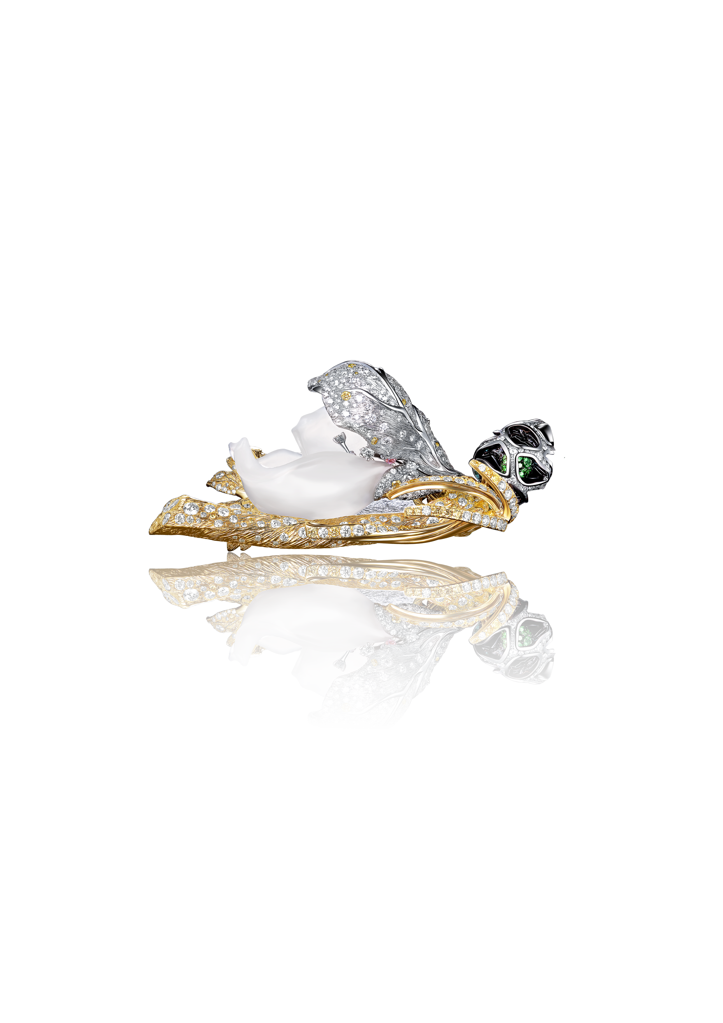 A luxurious butterfly-shaped brooch adorned with diamonds, gold, and emeralds, displayed against a black background with a mirror reflection.