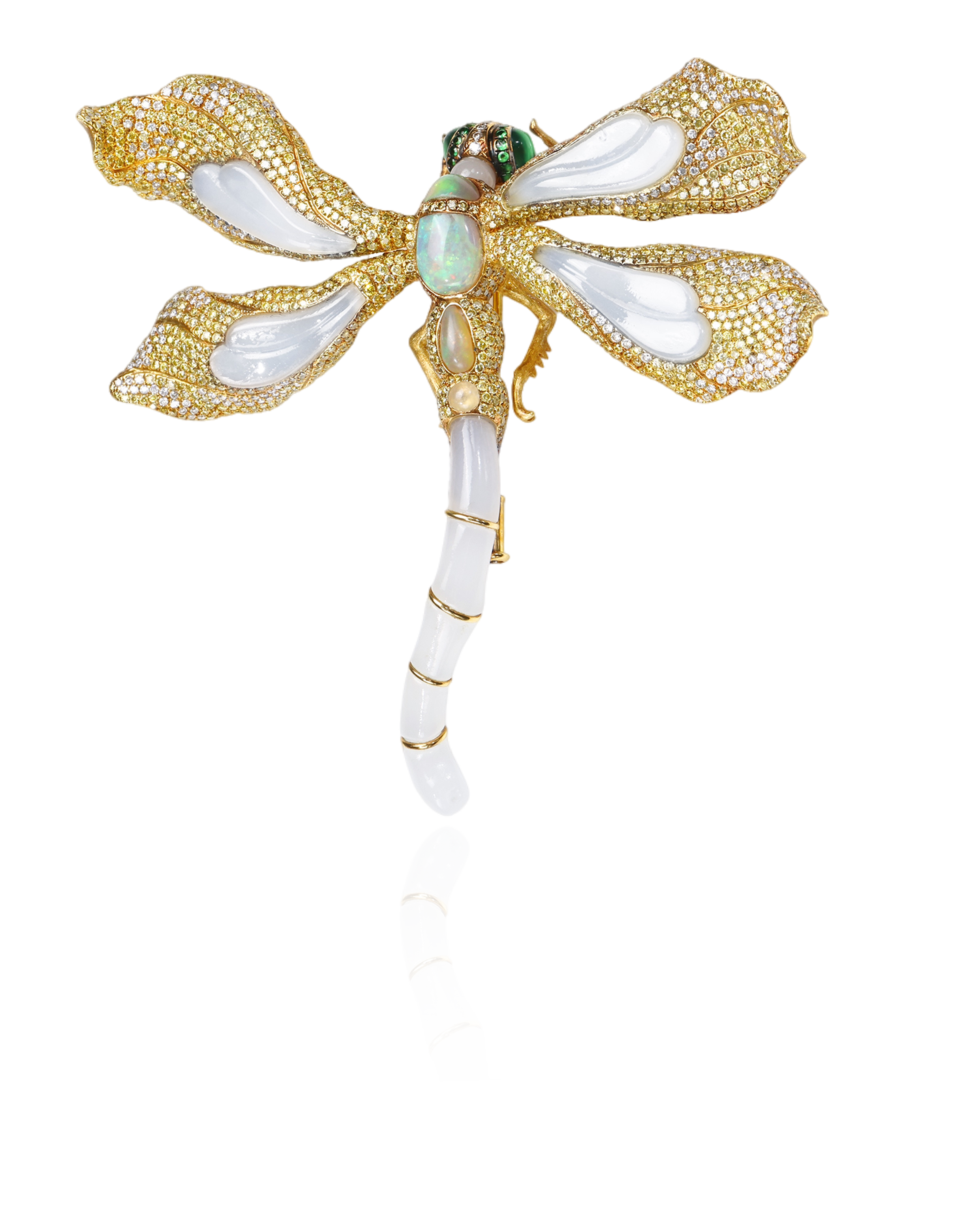 A decorative brooch in the shape of a dragonfly with gold, white, and green details, adorned with gemstones and enameled wings.