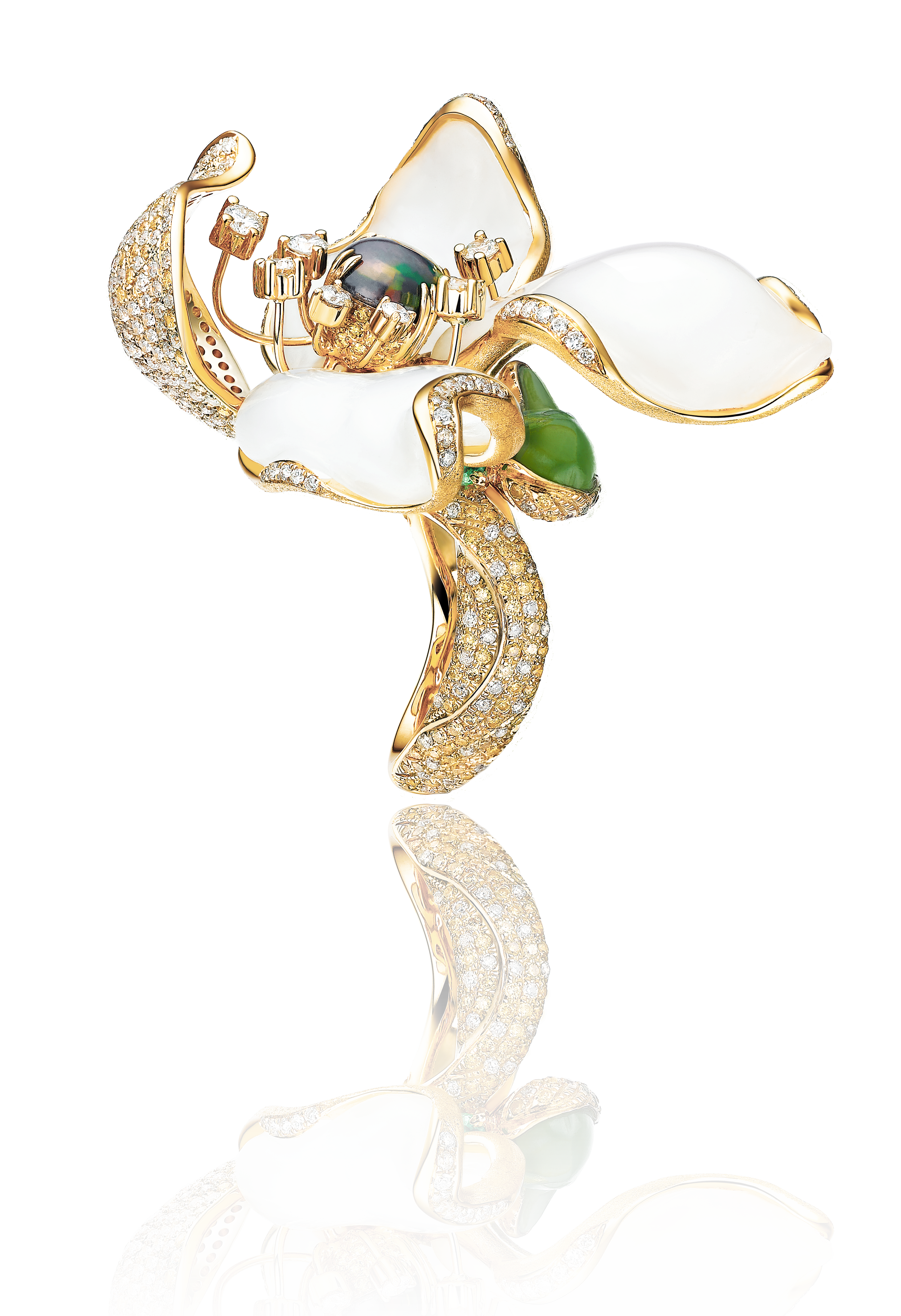 Gold and diamond jewelry brooch designed as a blooming lily flower with white enamel petals, green accent, and black pearl center, reflected on a black surface.