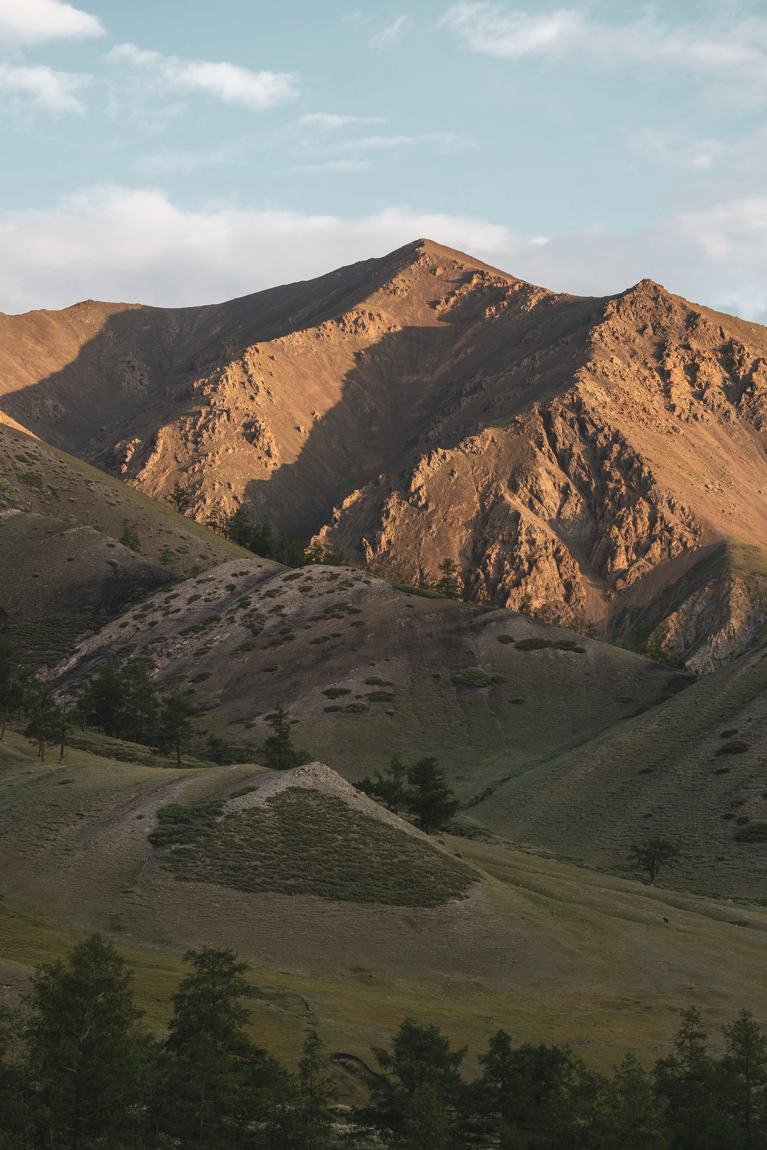 Mongolian mountain tops bathed in golden sunlight