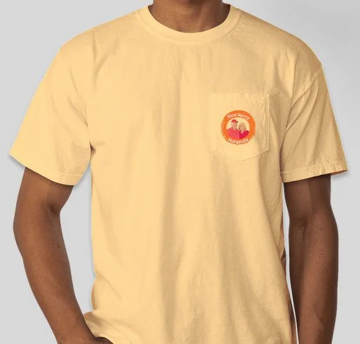 A person wearing a yellow T-shirt with a red and white circular patch on the left chest that says 'Vote Name' and 'Nonprofit' with an illustration of a person.