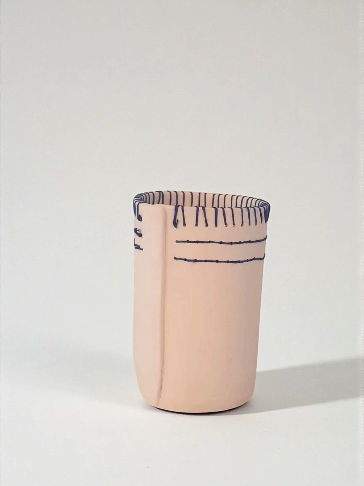 Vase en céramique rose pâle avec lignes bleues décoratives