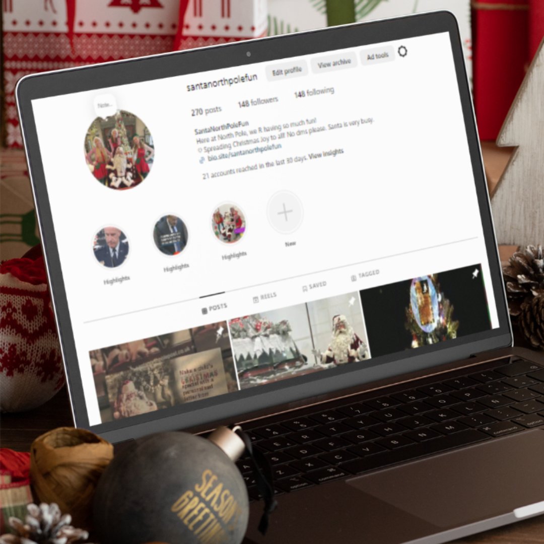 Apple MacBook displaying SantaNorthPoleFun Instagram profile with Christmas-themed posts and highlights, surrounded by holiday decorations and ornaments.