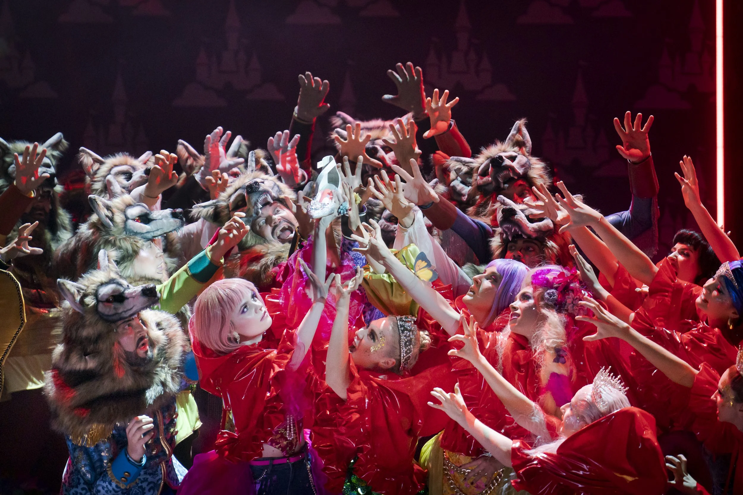 Menschen in Tierkostümen und farbenfrohen Outfits, die auf einer Bühne eine Emotion der Freude und Energie zeigen.