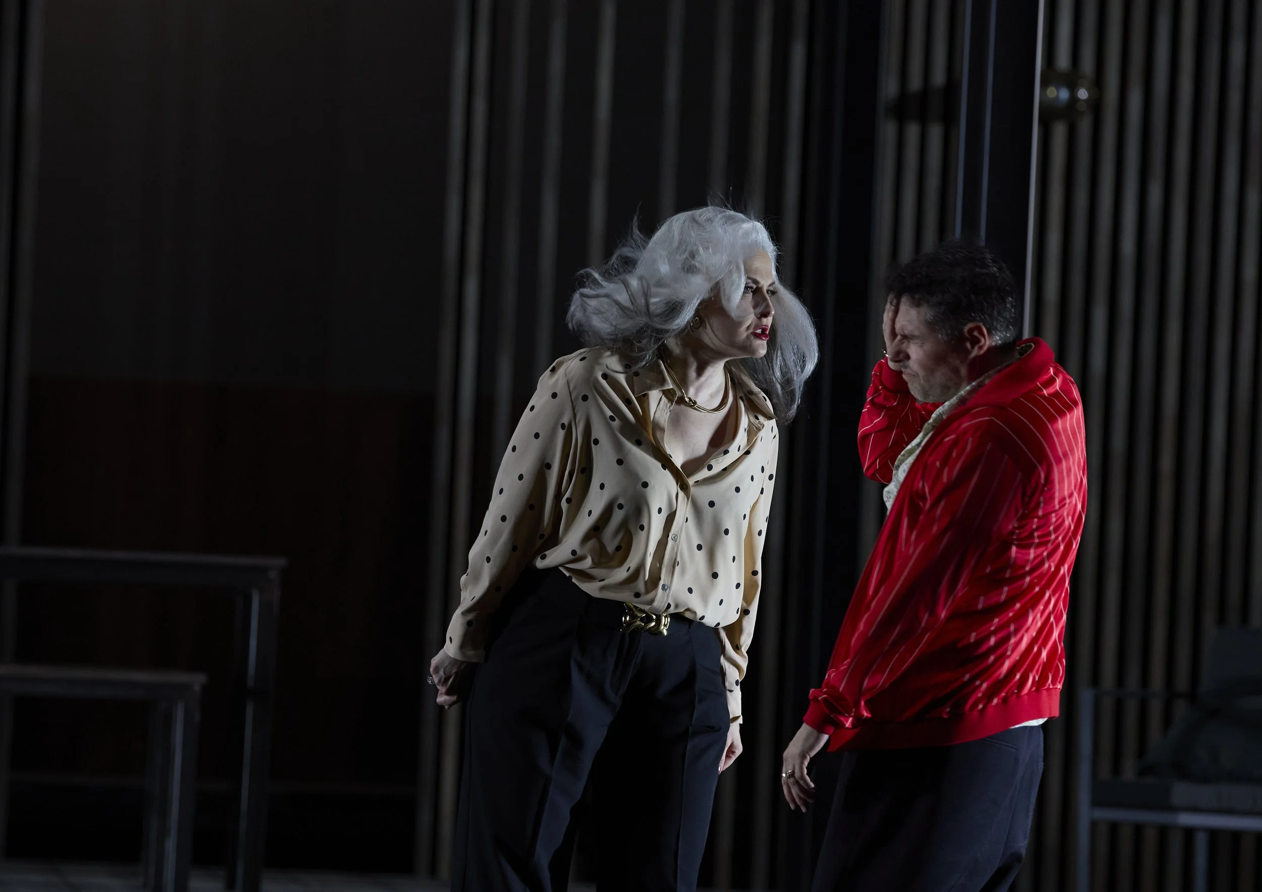 Zwei Menschen im Theater, die in einem intensiven Gespräch vertieft sind.