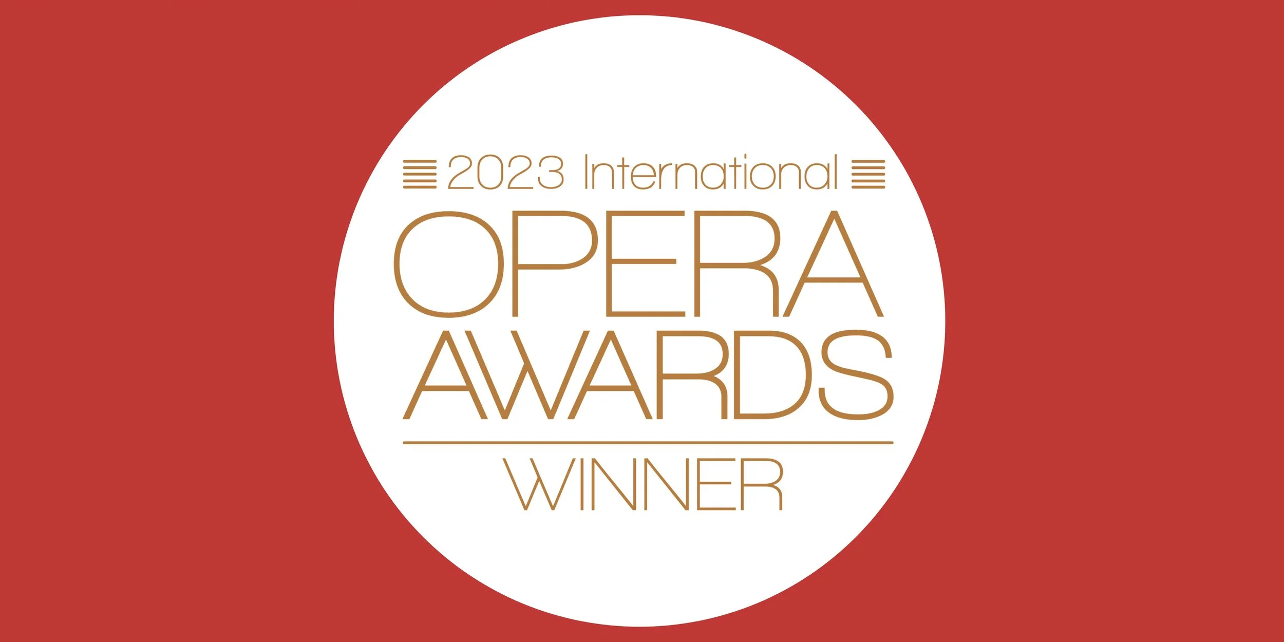 Logo des Internationalen Opera Awards 2023 mit rotem Hintergrund und weißem Kreis, darin goldene Schrift '2023 International Opera Awards Winner'.