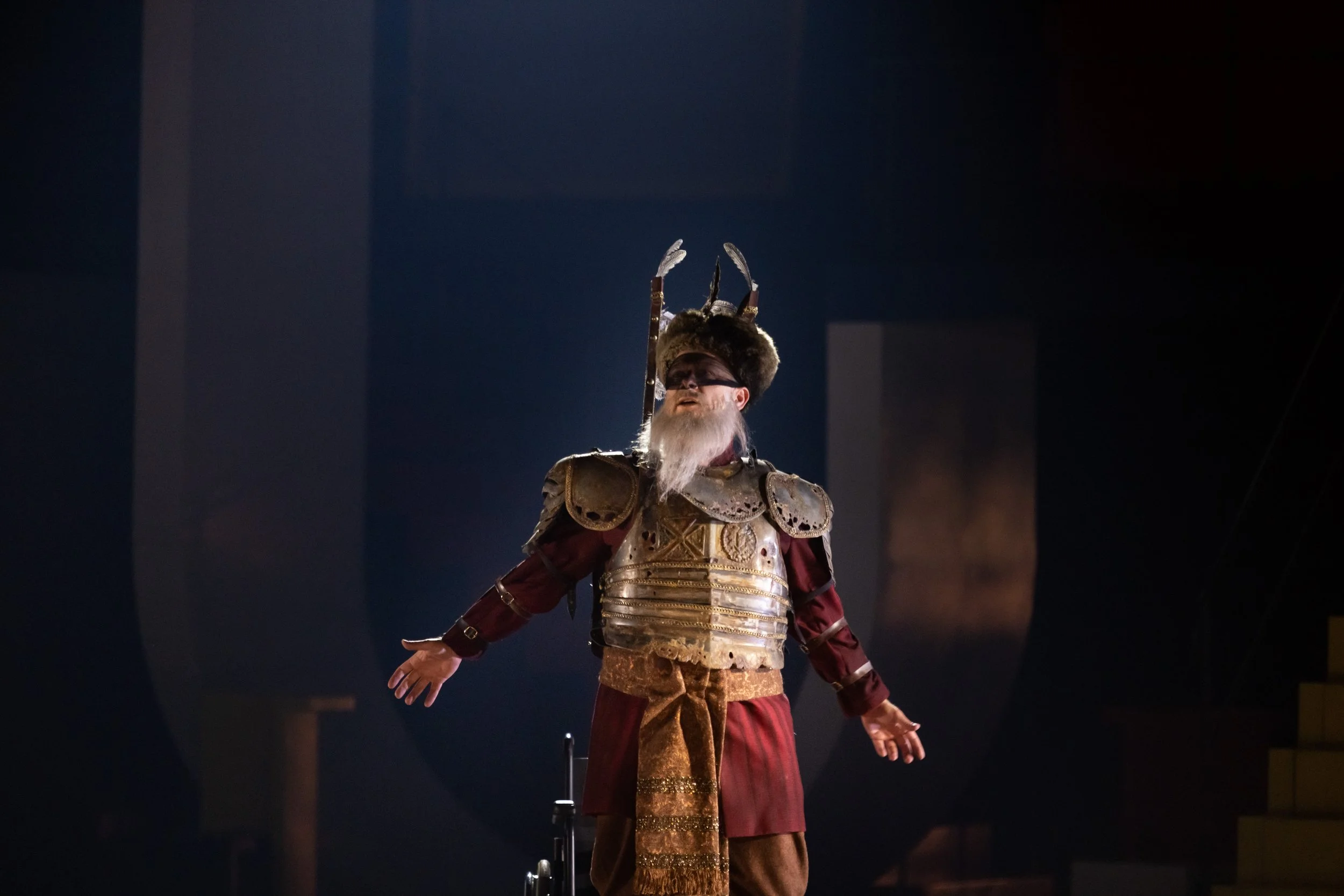 Ein Schauspieler in historischem Kostüm mit Rüstung und exotischem Hut auf einer Bühne.