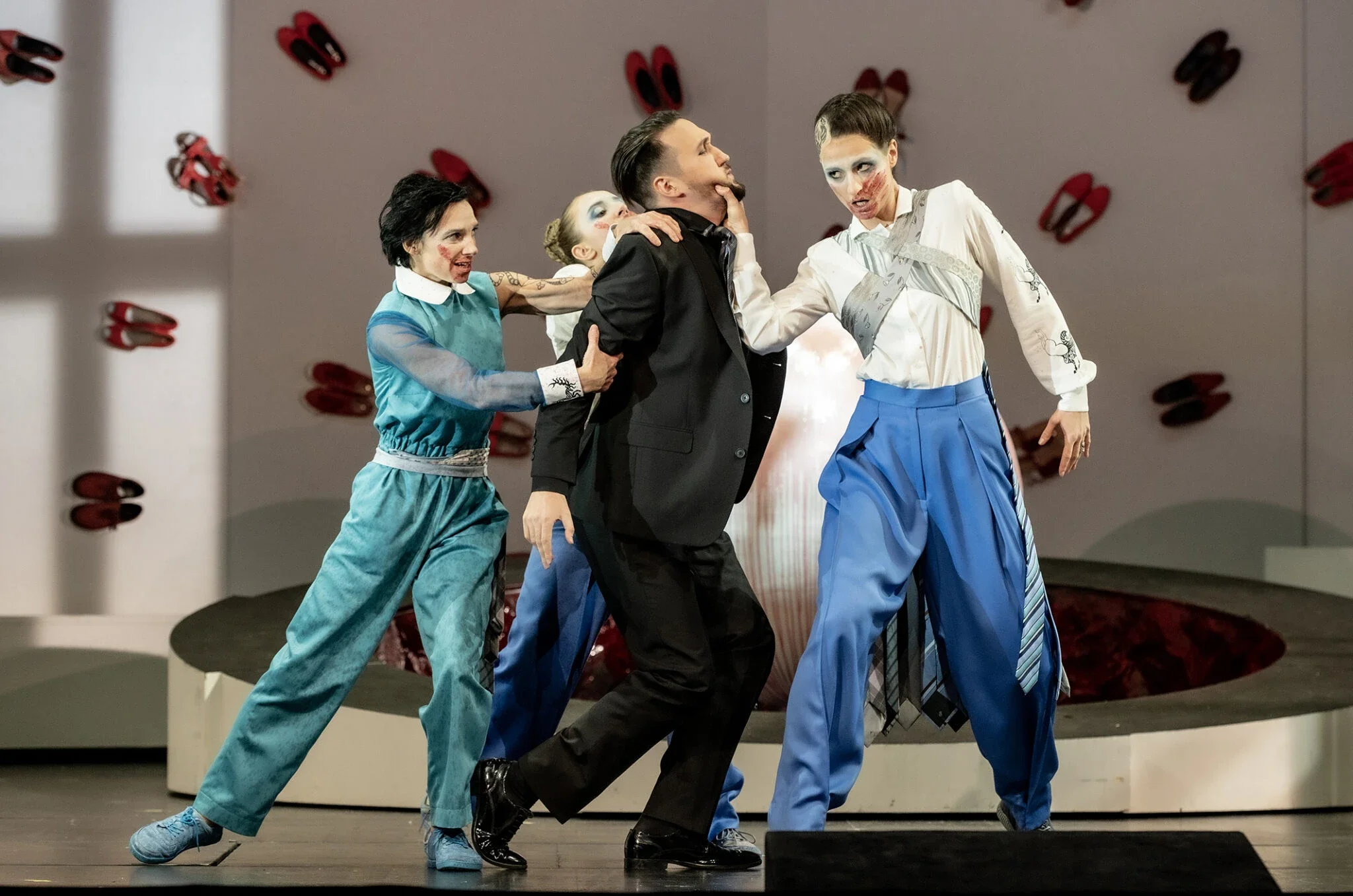 Theaterstück mit mehreren Schauspielern in bunter Kleidung auf einer Bühne, Szene mit Konflikt