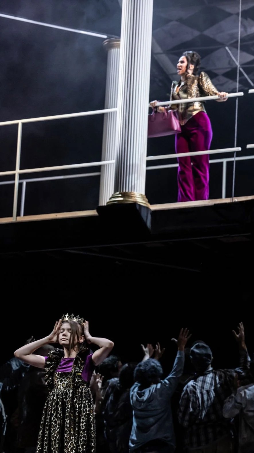Eine Frau steht auf einer Bühne im oberen Bereich, trägt eine goldene Jacke und violette Hosen, hält eine Stange und hat eine pinke Tasche. Unten befindet sich ein junges Mädchen, das eine Krone trägt, in einem Leopardenkleid und violetter Kleidung, umgeben von einer Gruppe von Menschen mit erhobenen Händen.