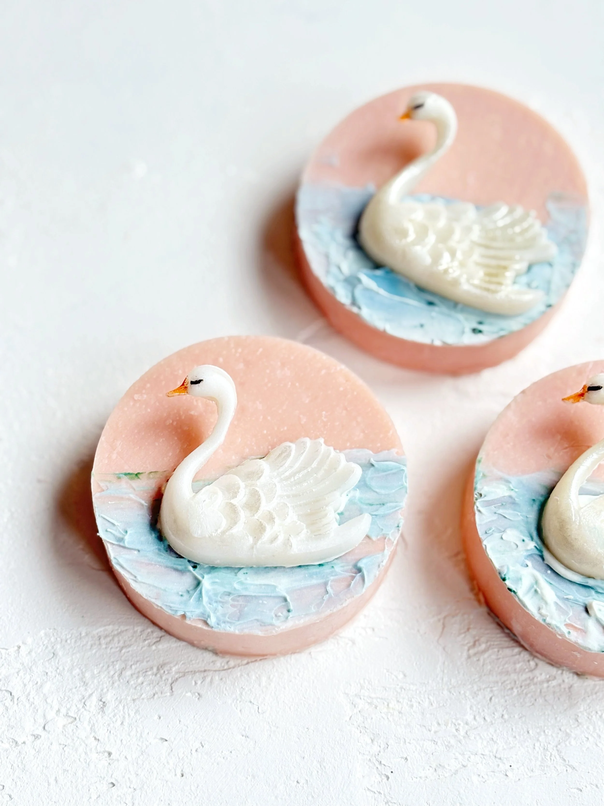 Decorative cookies shaped like swans with pink, blue, and white icing.