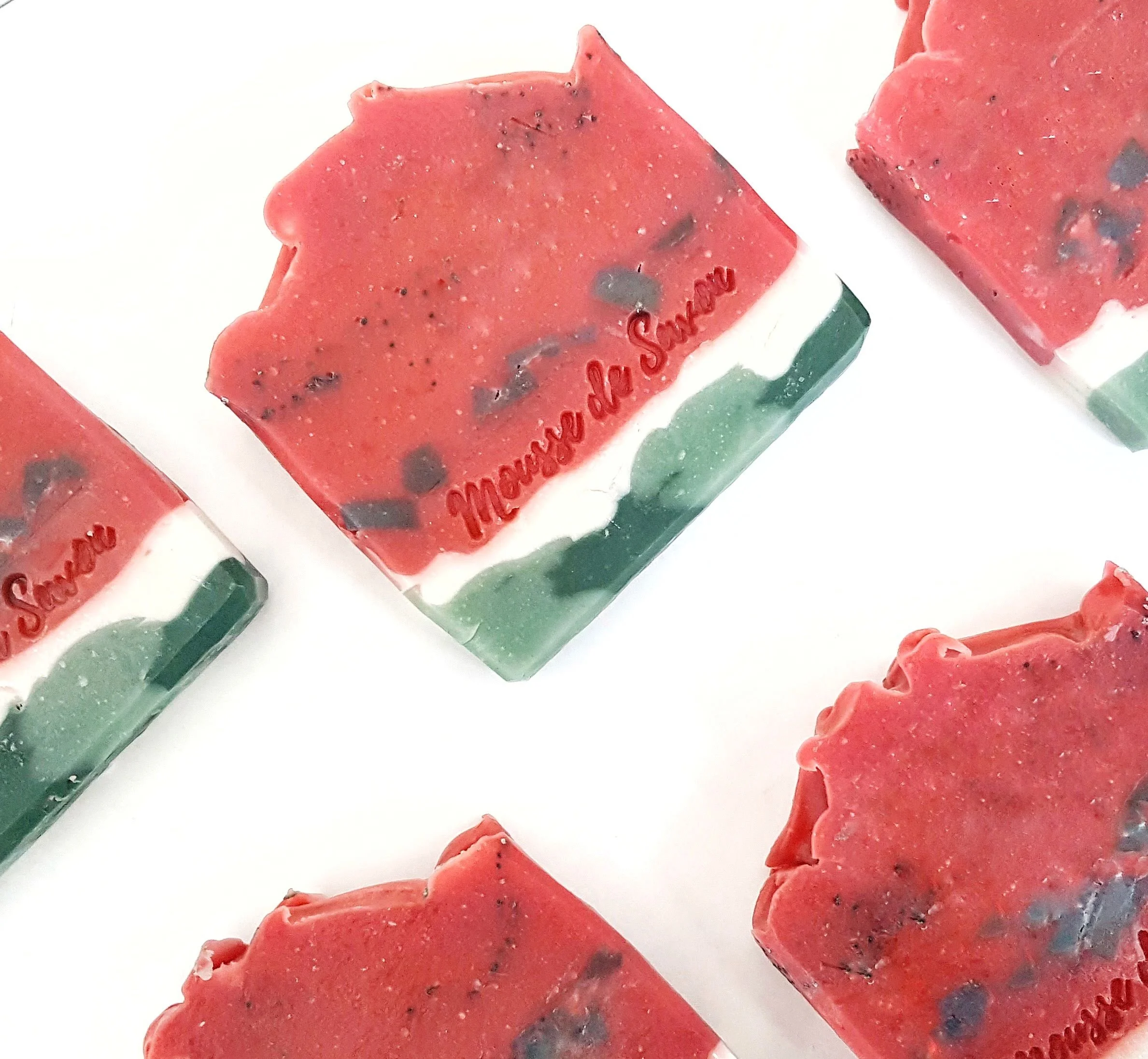 Colorful soap bars with red, white, and green layers, embossed with the words "Marseille de Savon."
