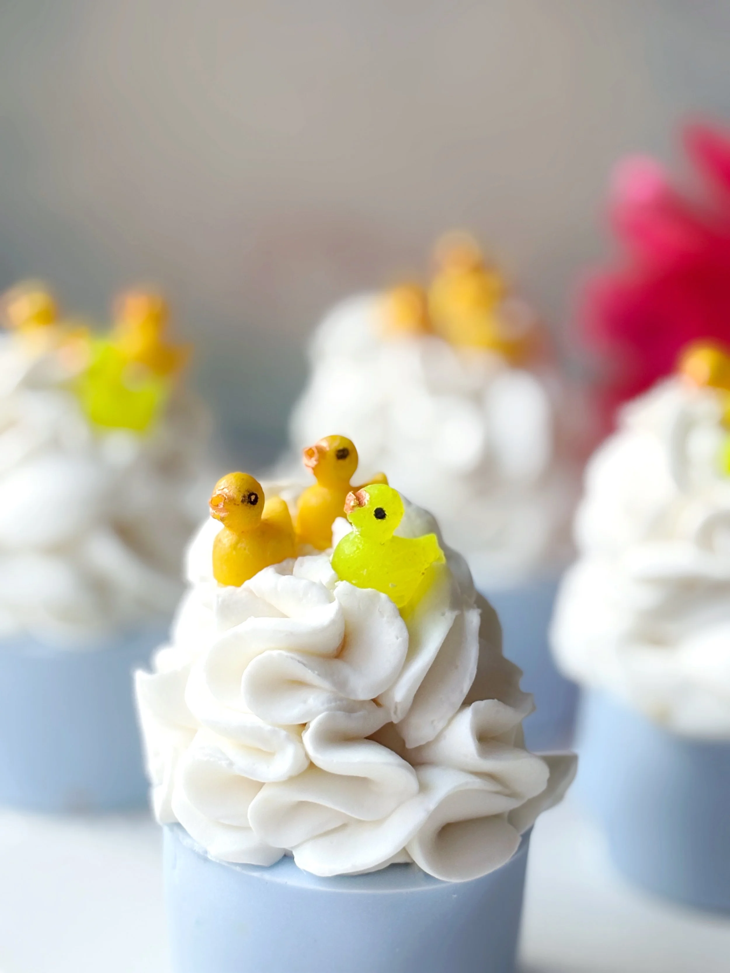 Soap with white frosting topped with yellow bird and duck-shaped 