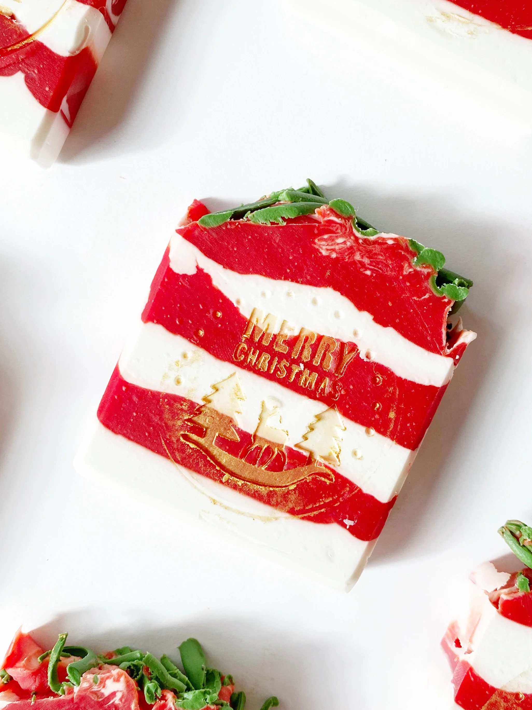 A Christmas-themed soap with red, white, and green colors, decorated with holiday messages and Christmas tree designs.