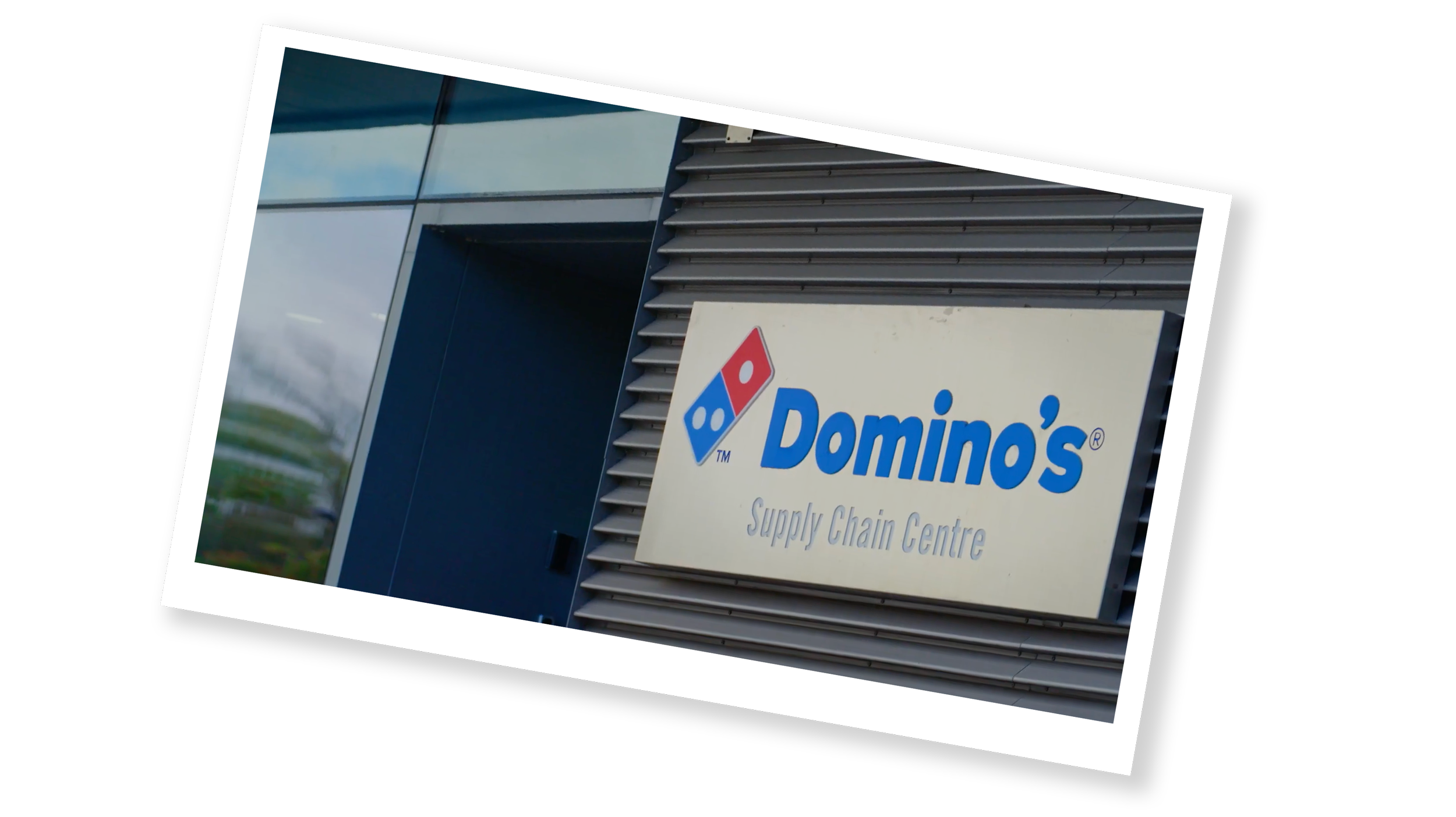 Exterior of a Domino's Supply Chain Centre with a sign displaying the Domino's logo and name.