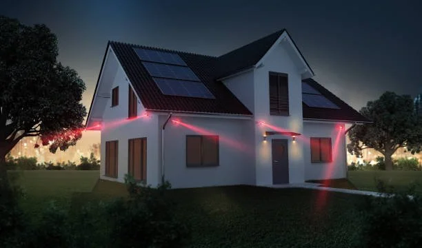 Ein Haus mit Solarpaneelen auf dem Dach wird von einem Laserstrahl-Scanner gemessen, während das Licht im Hintergrund dunkel ist.