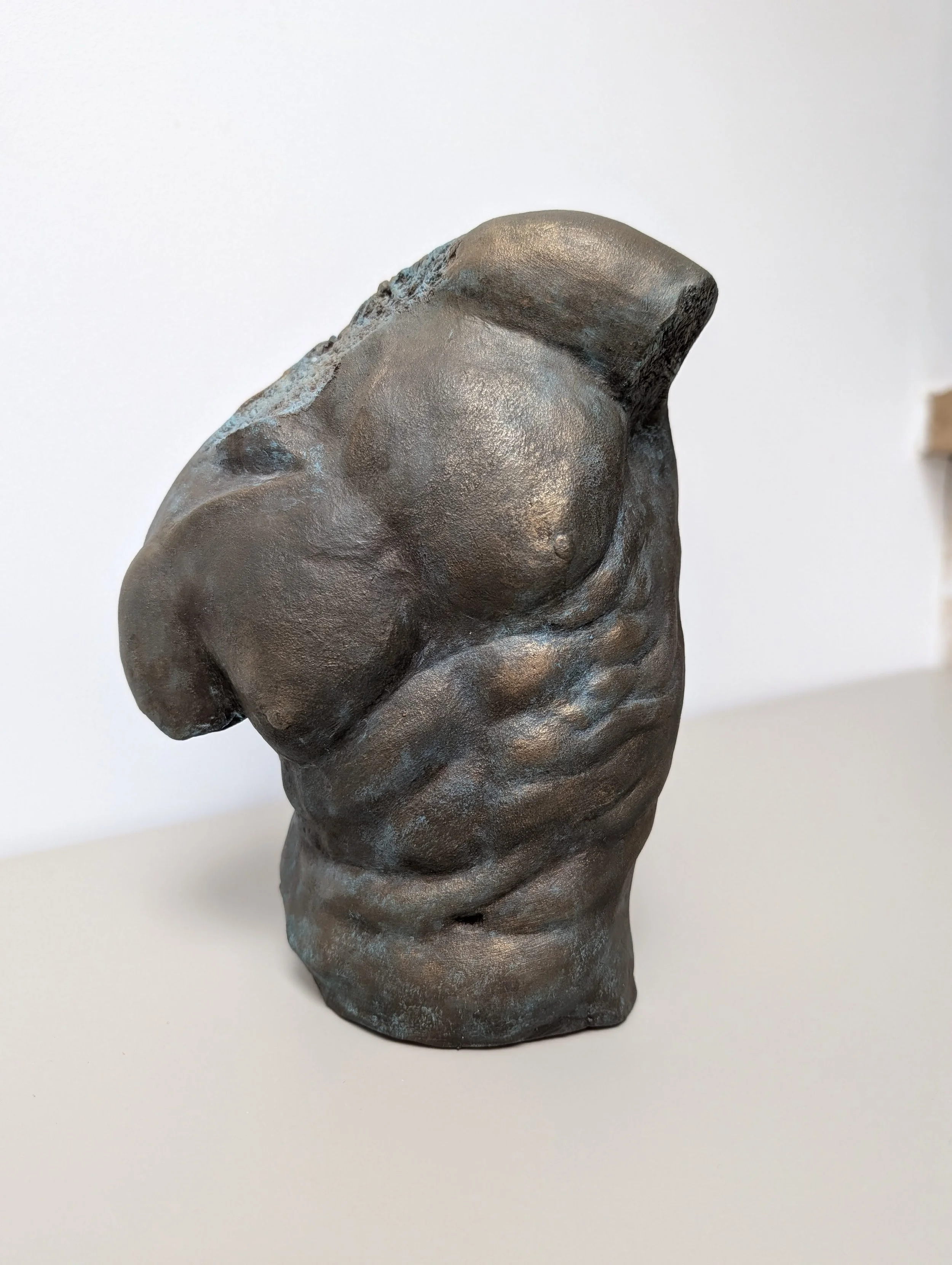 Statue de bronze d'un torse humain sans tête ni bras.