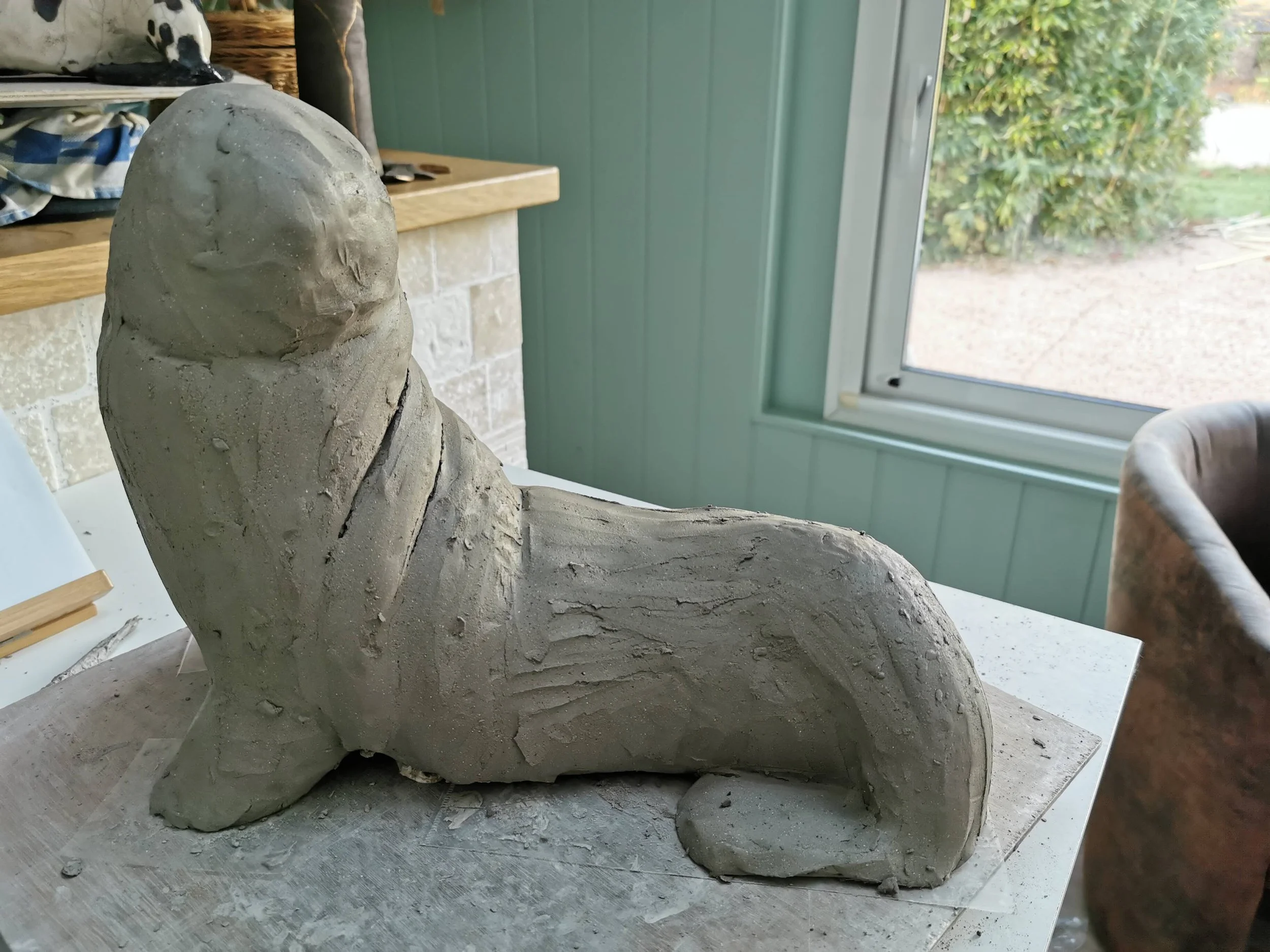 Une sculpture en argile en cours de fabrication représentant un phoque.