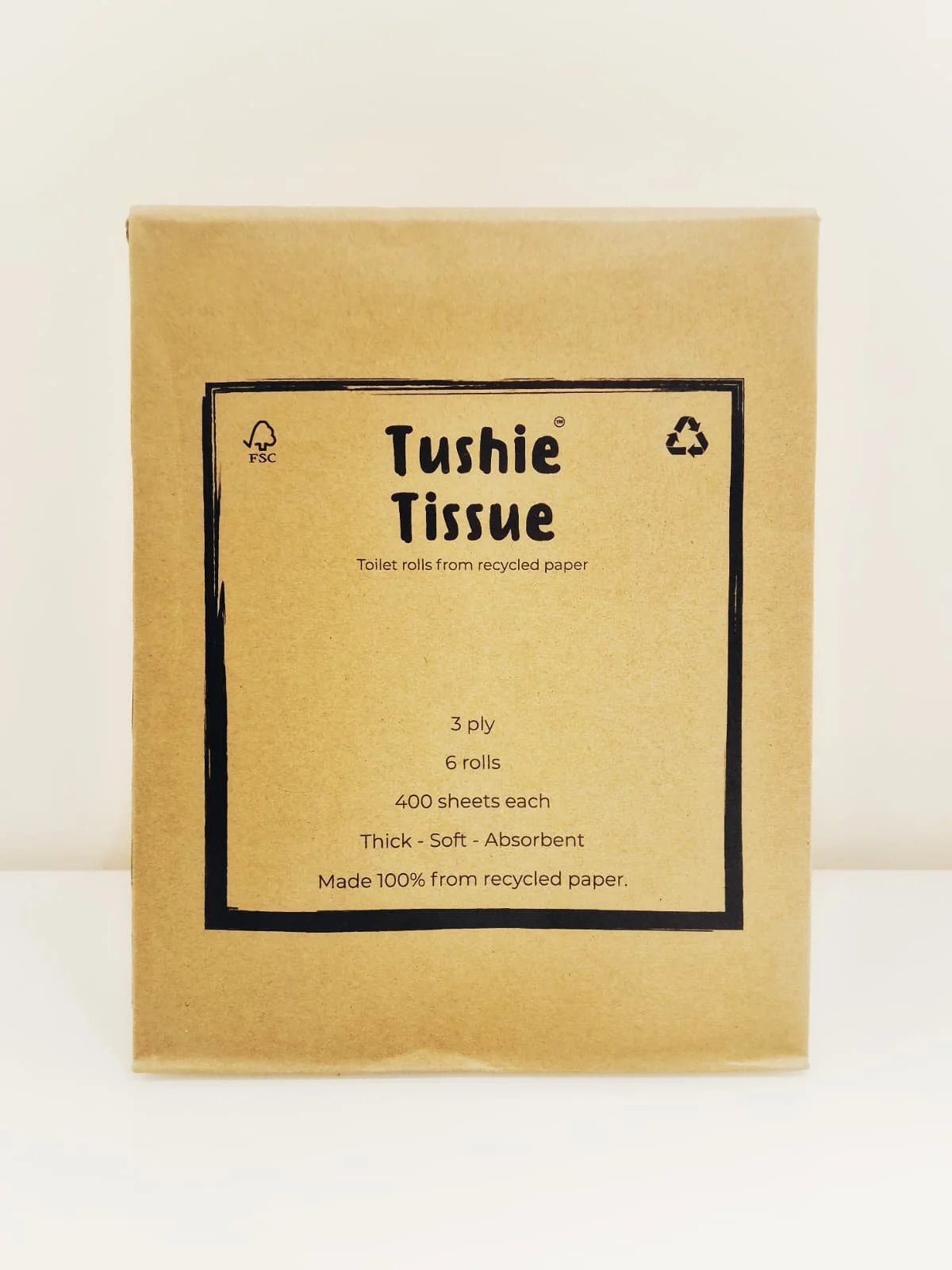 Box of recycled toilet paper rolls labeled 'Tushie Tissue' with details about the product.