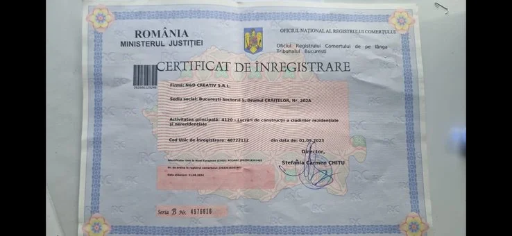 Romanian business registration certificate with government and official emblems, showing registration details and signature.