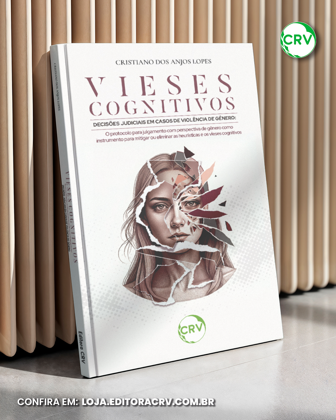 Livro com capa branca intitulado 'Vieses Cognitivos: Decisões Judiciais em Casos de Violência de Gênero' de Cristiano dos Anjos Lopes, com ilustração de rosto de mulher parcialmente rasgado na capa, ao lado de uma prateleira de madeira.