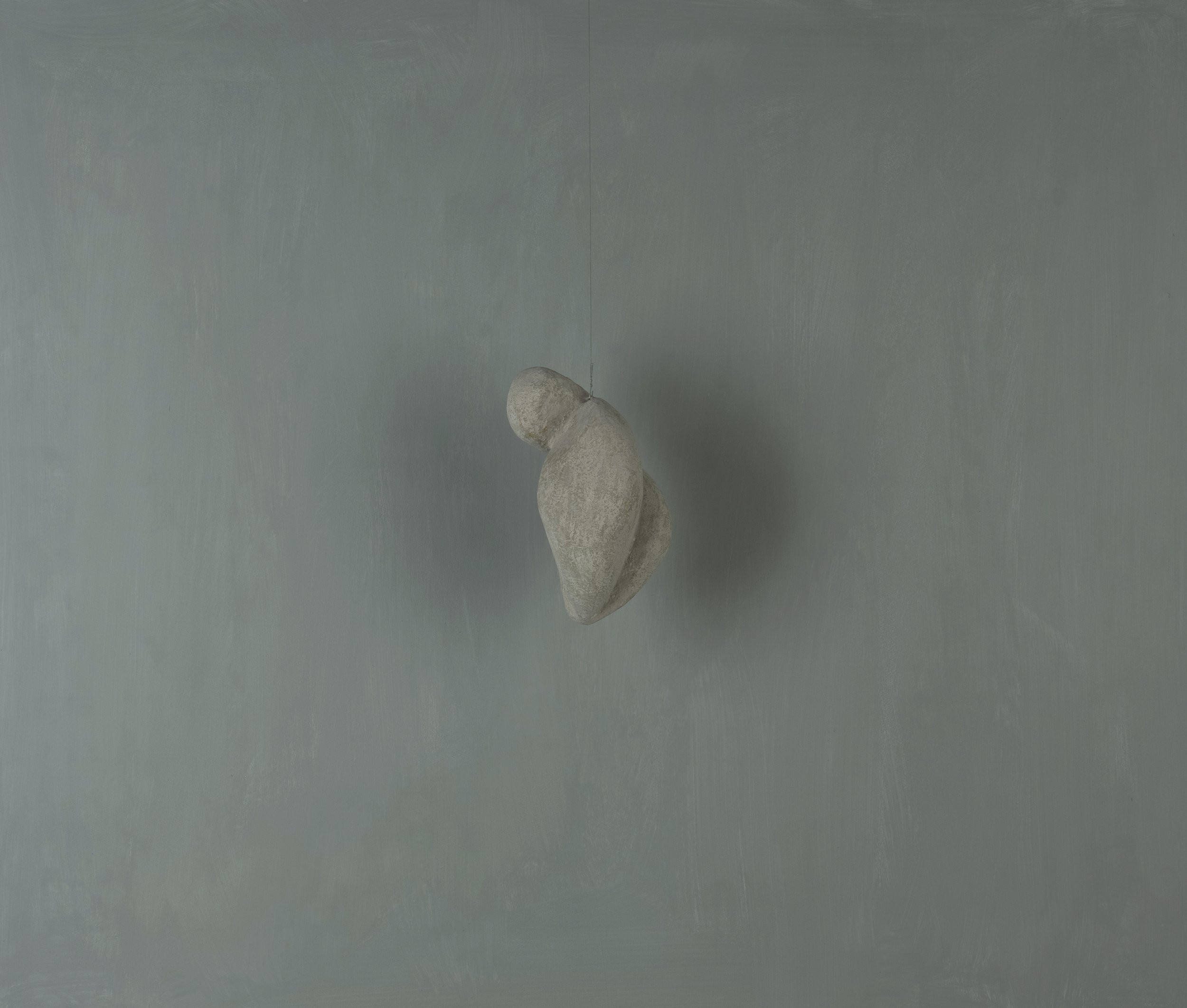Una composizione di due pietre grigie appoggiate su una superficie grigia.