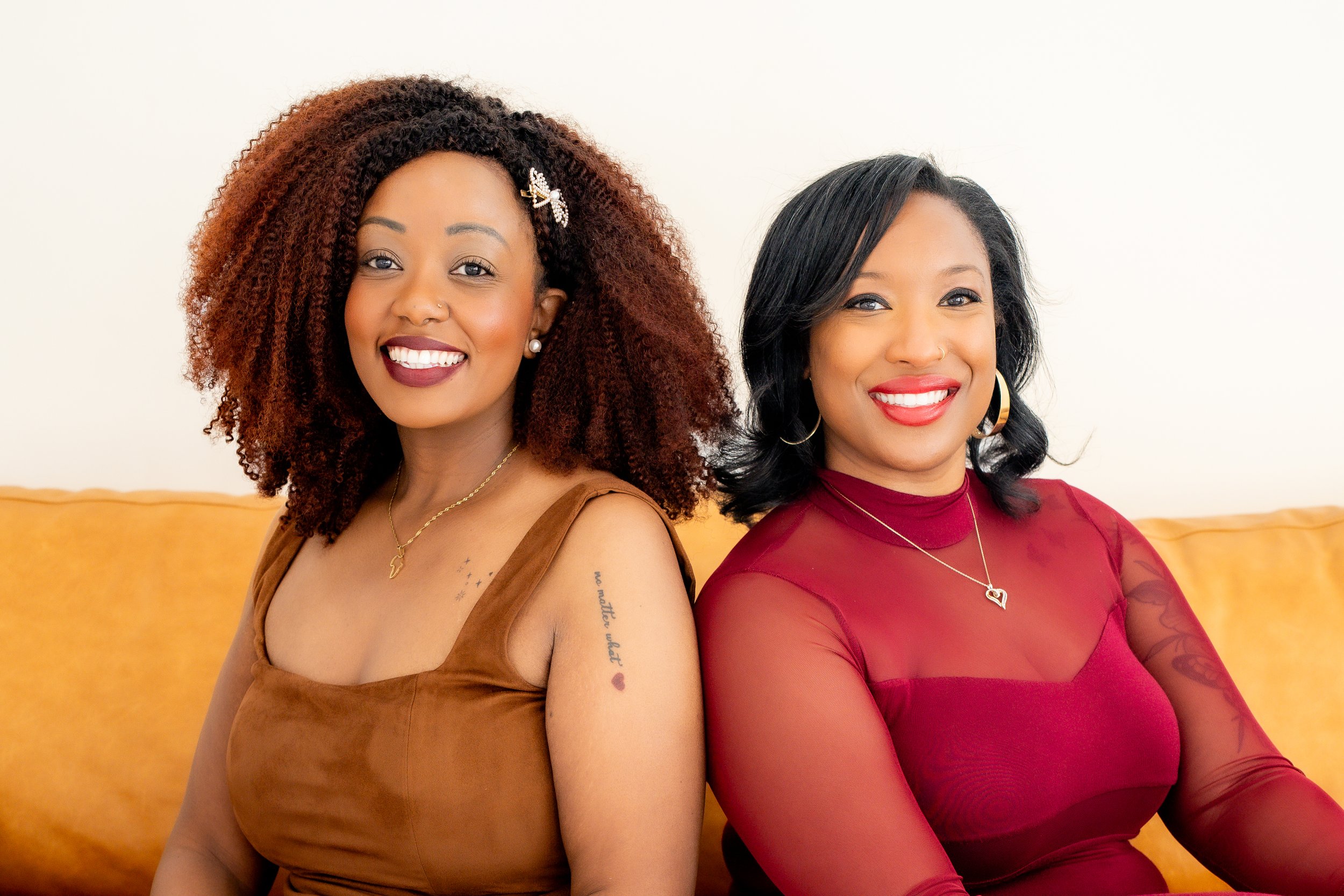 Two women smiling together in a welcoming wellness setting.