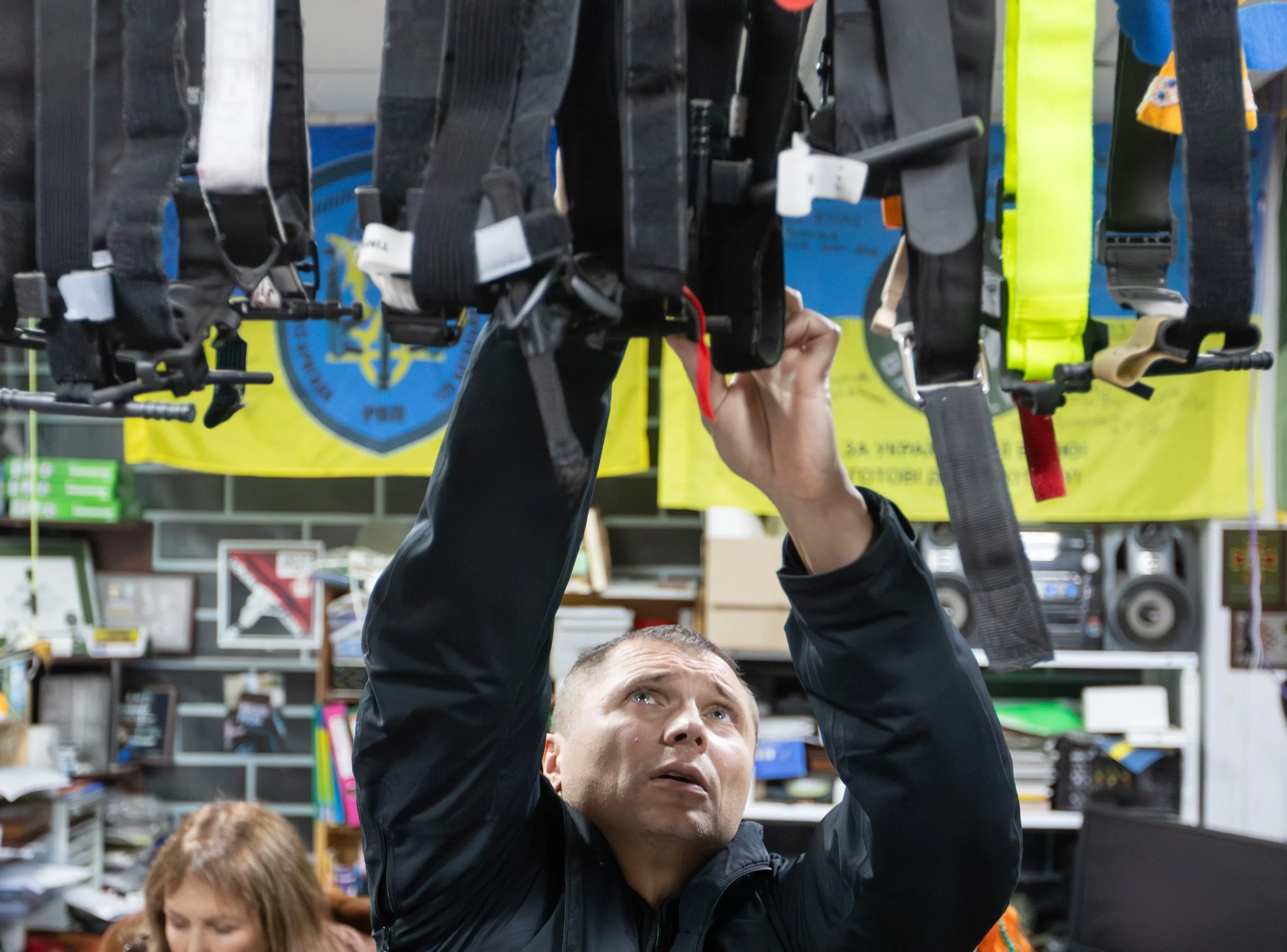 Maksym Pozhydaiev, project manager, reaches for tourniquets hanging on a wire that are deemed bad quality Nov. 28, 2025, inside a military storage unit in Kharkiv, Ukraine.