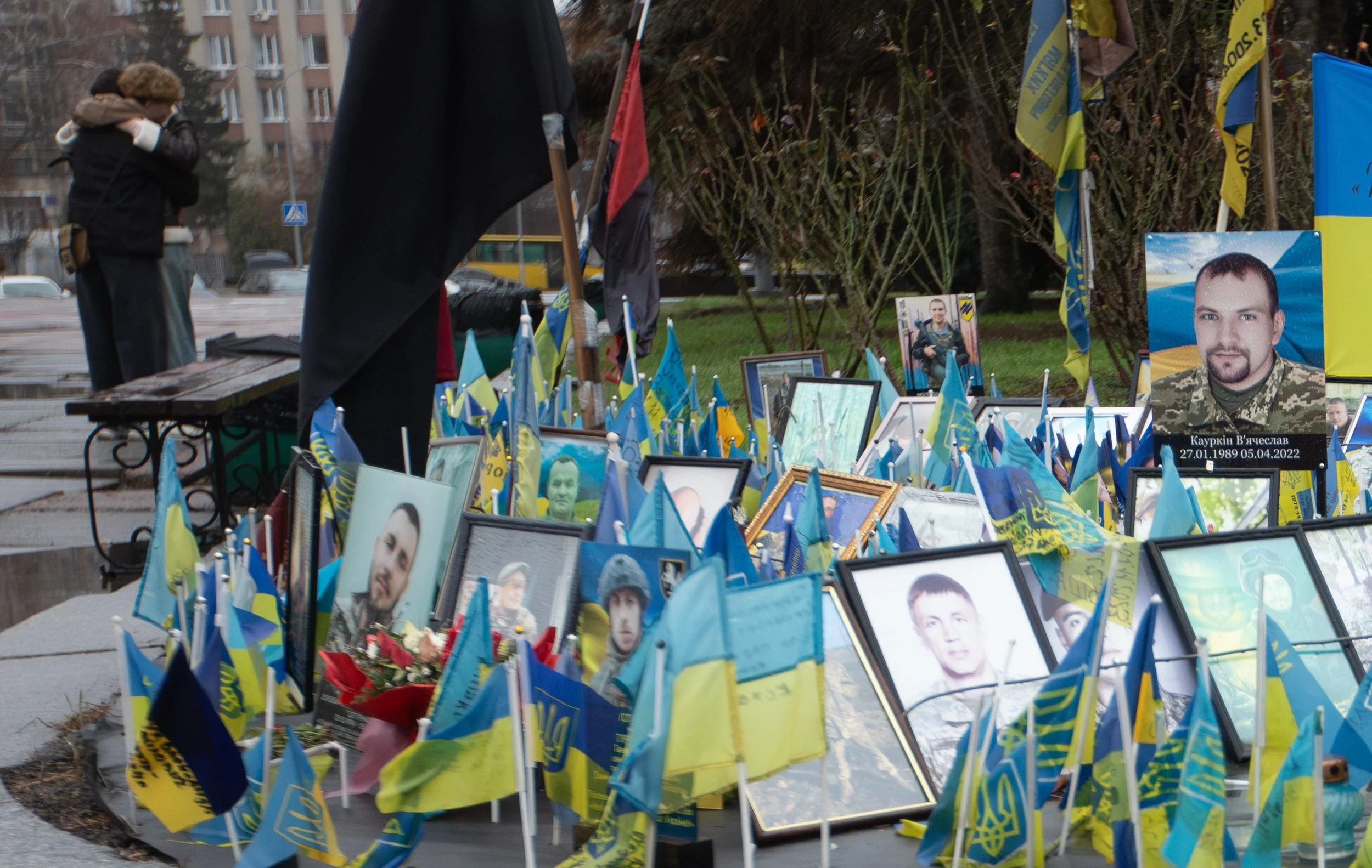 A couple comforts each other Nov. 22, 2025 next to a memorial for dead soldiers in Zhytomyr, Ukraine.