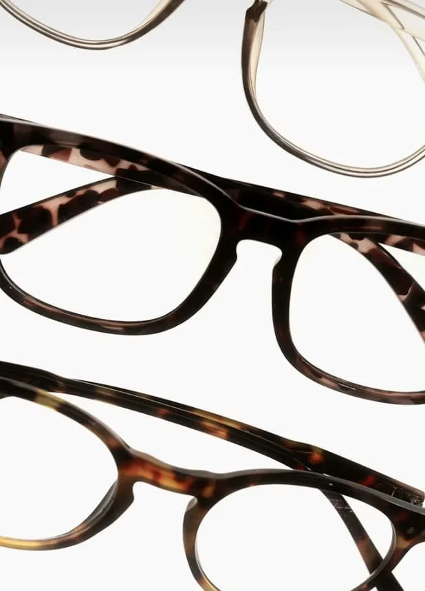 Four pairs of eyeglasses with different frame styles and colors arranged on a white background.