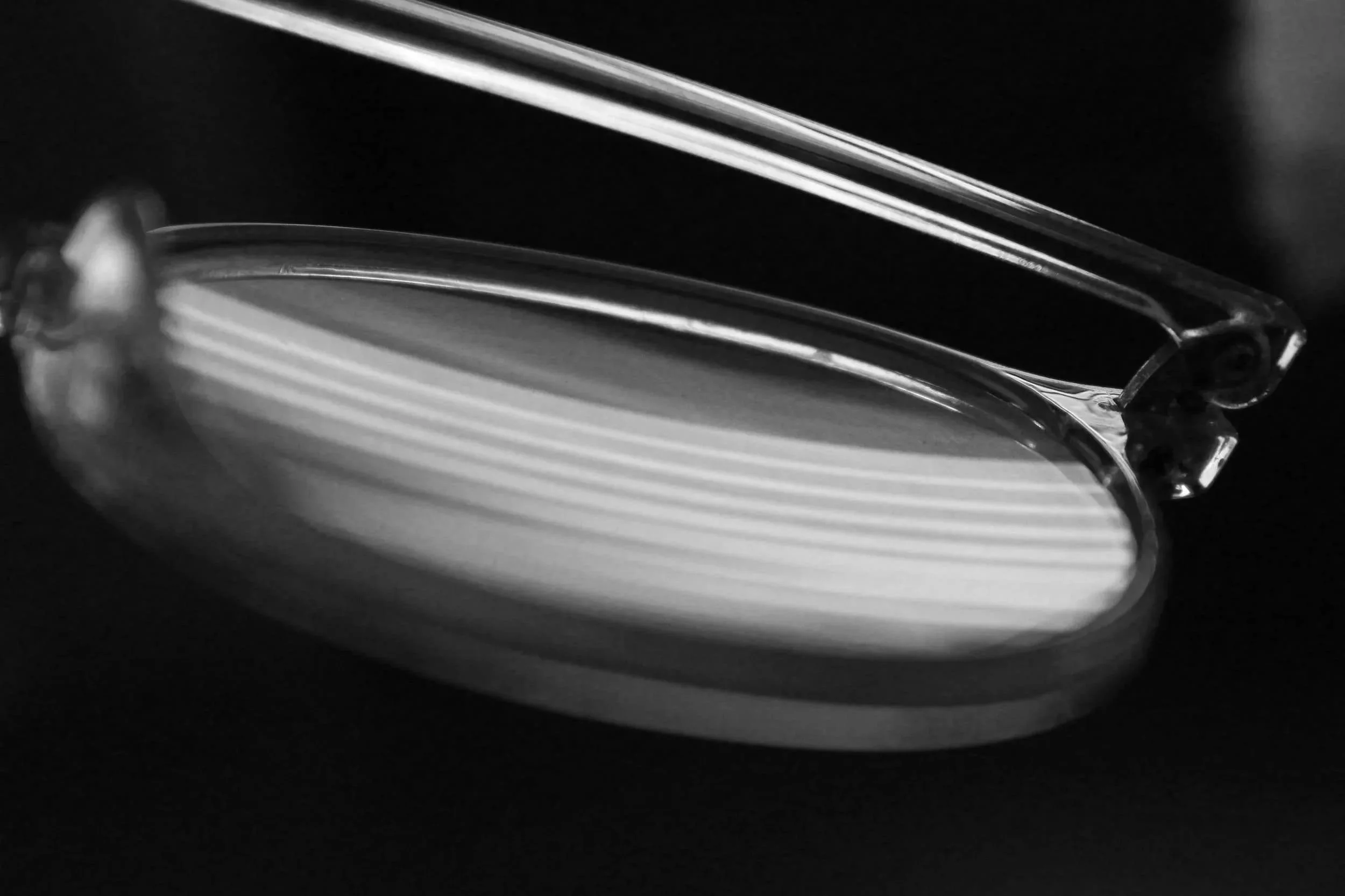 Close-up of clear glasses with reflections on a dark surface.