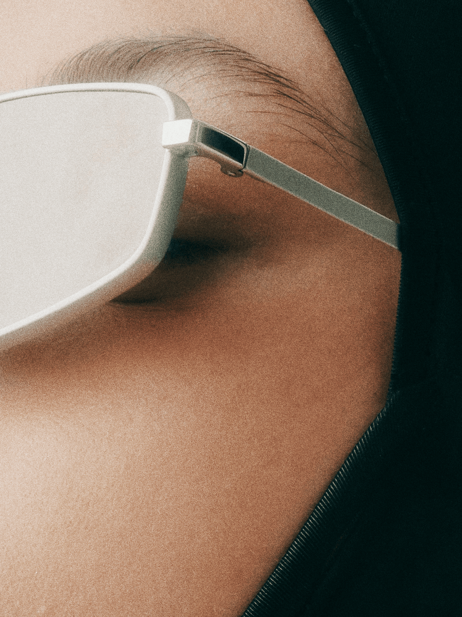 Close-up of a person's face wearing white sunglasses, focusing on the eye and eyebrow area.