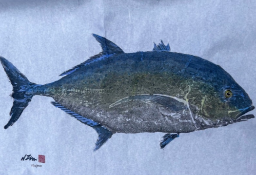 A fish with dark blue and greenish scales, lying on a white surface.